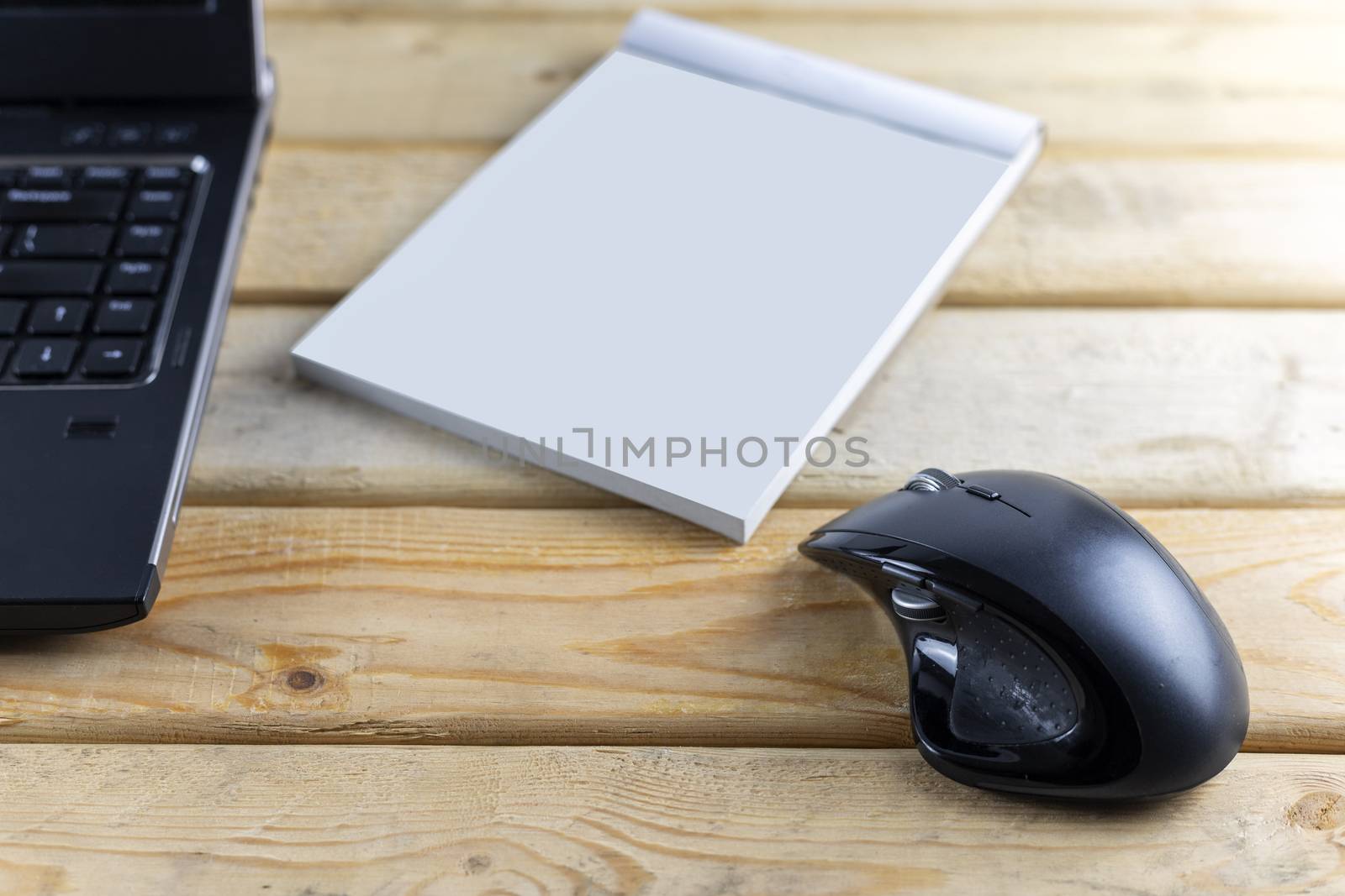 Office desk with mouse, laptop, bill book and pen on wood table . With copy space for text or design.