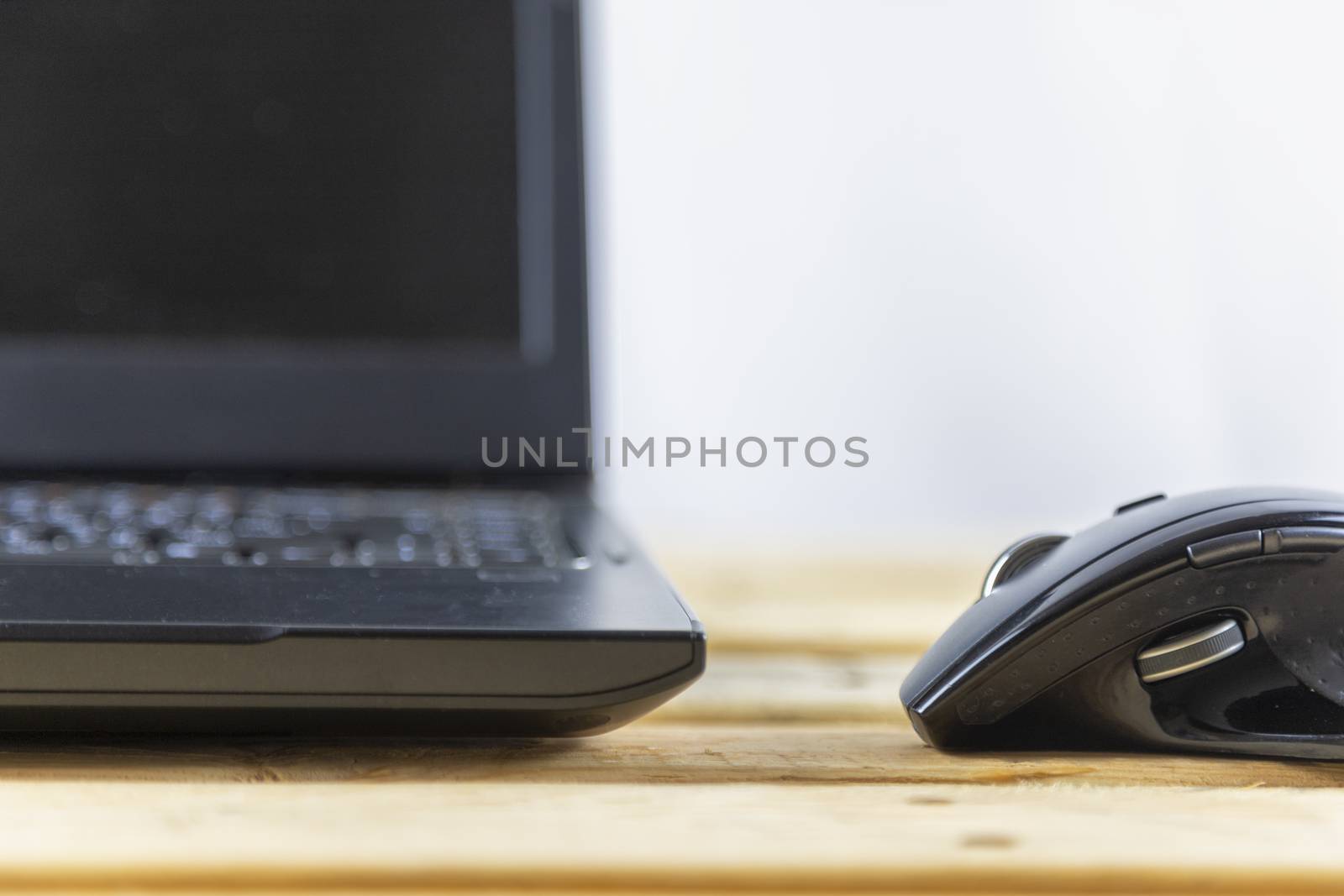 Office concept. Close up mouse and laptop on wood table. With copy space for text or design.