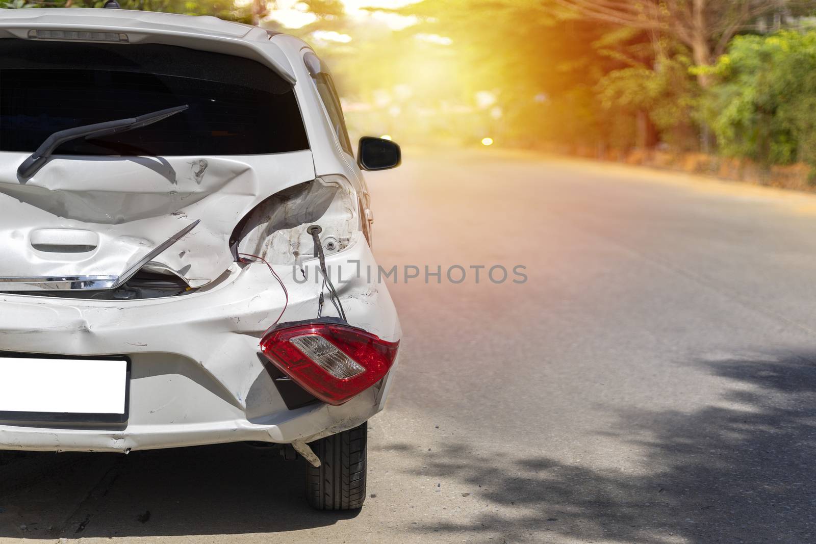 Back of white color car have big damaged and broken by accident on road in morning time can not drive any more park for wait insurance officer. With copy space for text or design
