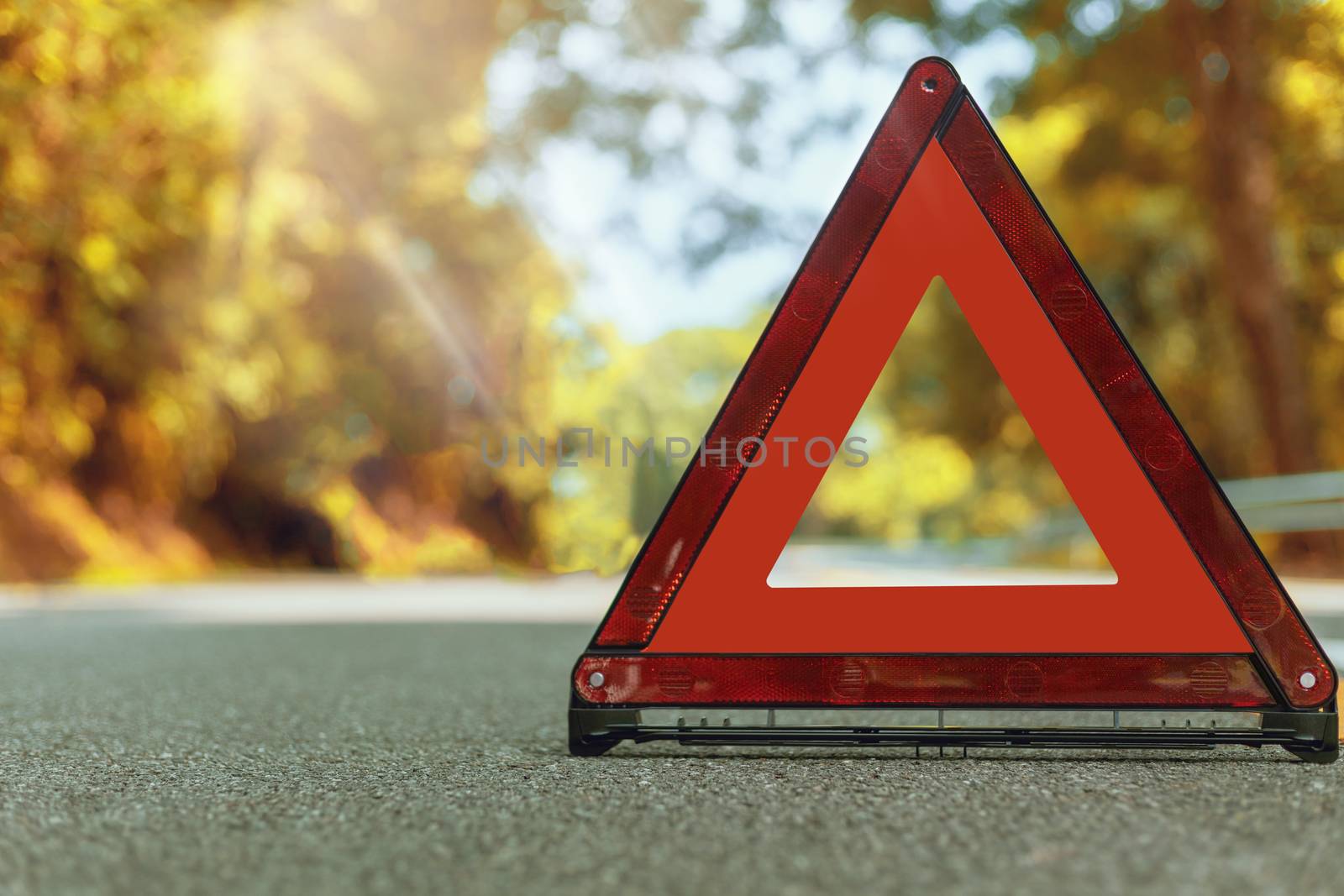 Autumn road red triangle, red emergency stop sign, red emergency symbol and black car stop and park on road.