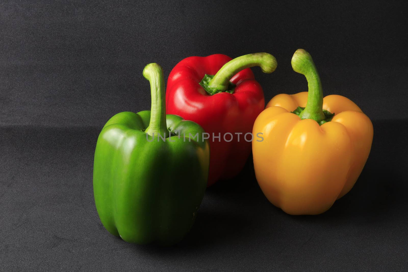 Fresh Green, yellow, red bell pepper. Sweet pepper. Giant pepper on black background. 