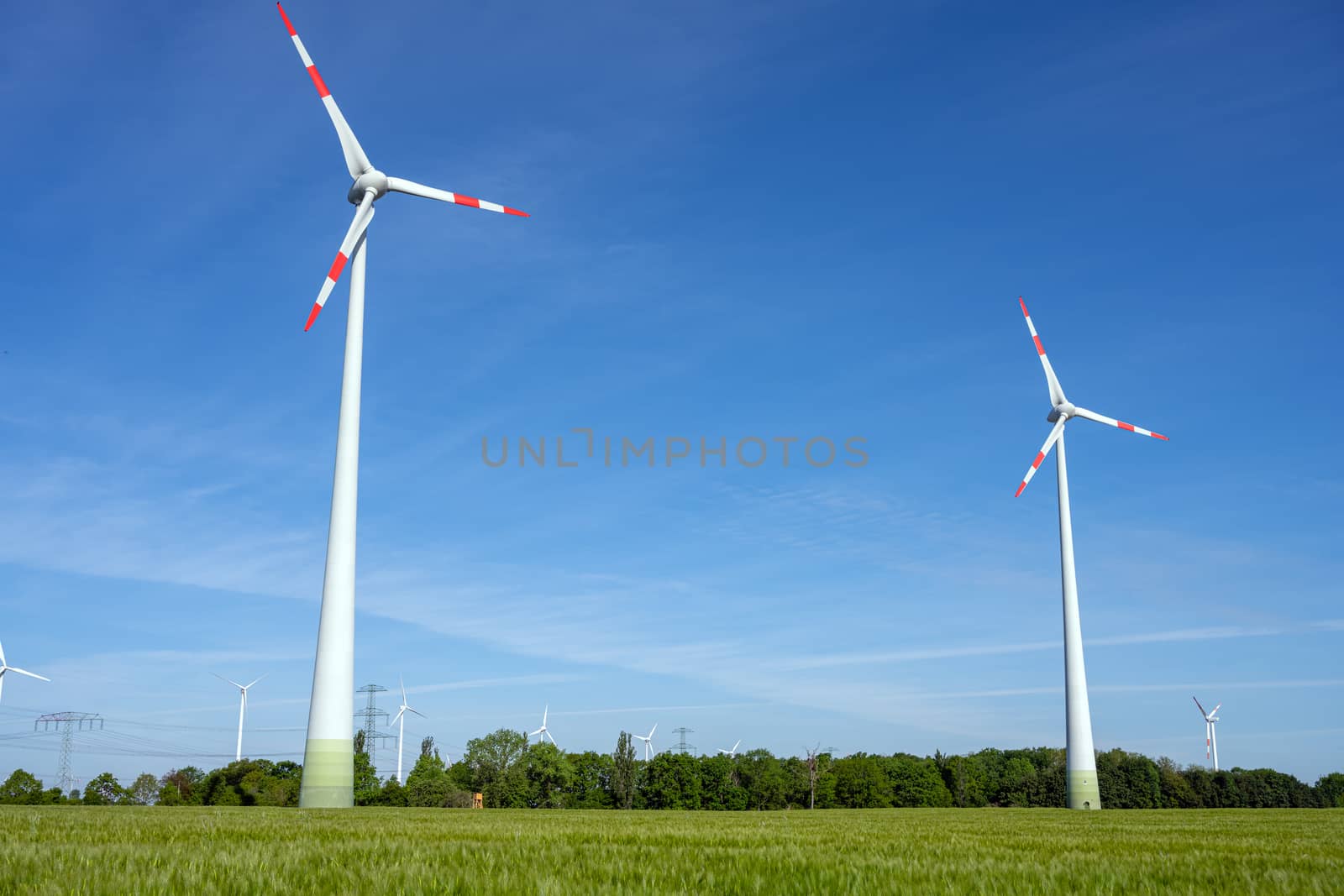 Modern wind turbines with a clear blue sky by elxeneize
