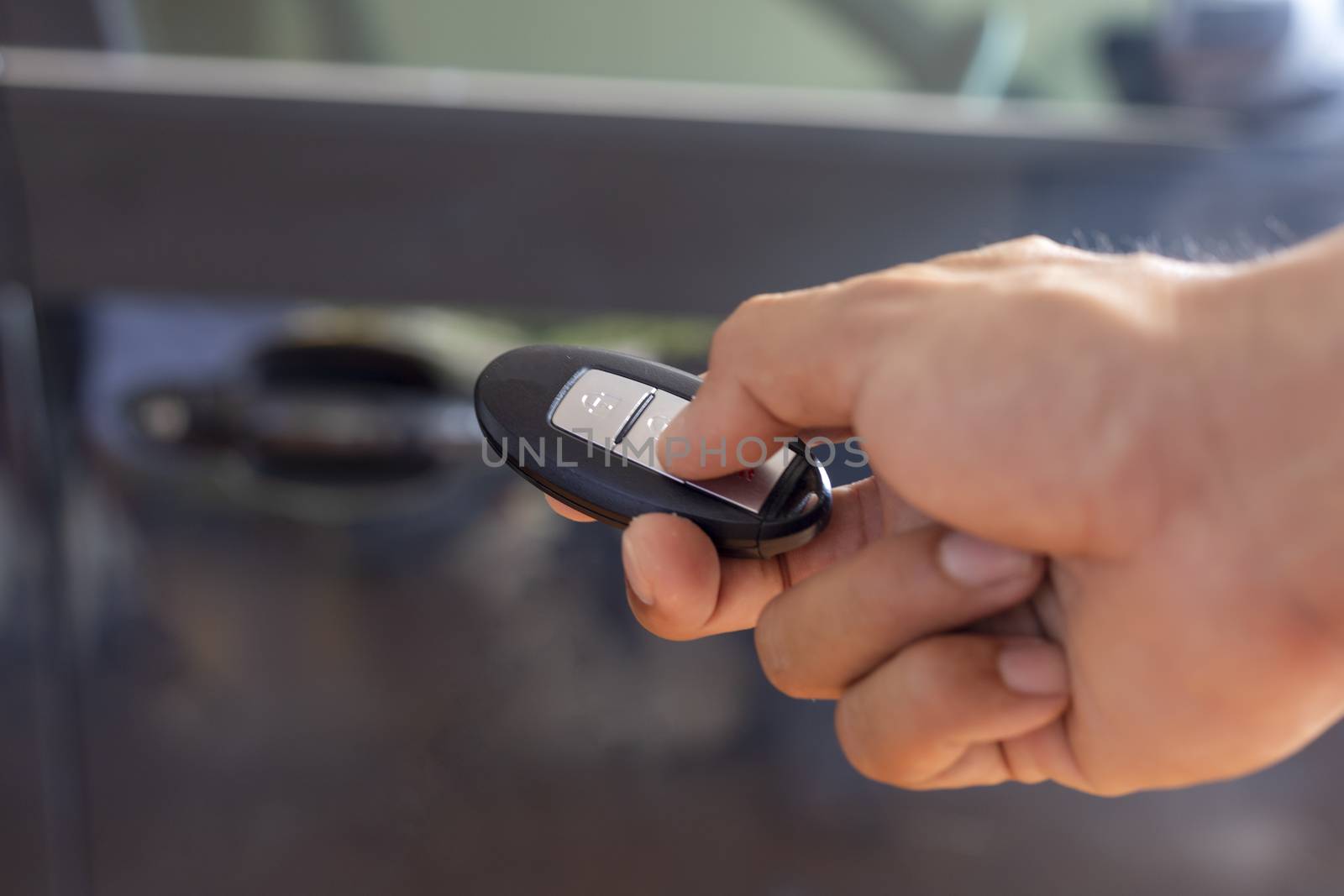 Hand man hode car remote for open the car. Soft focus and focus selective remote.