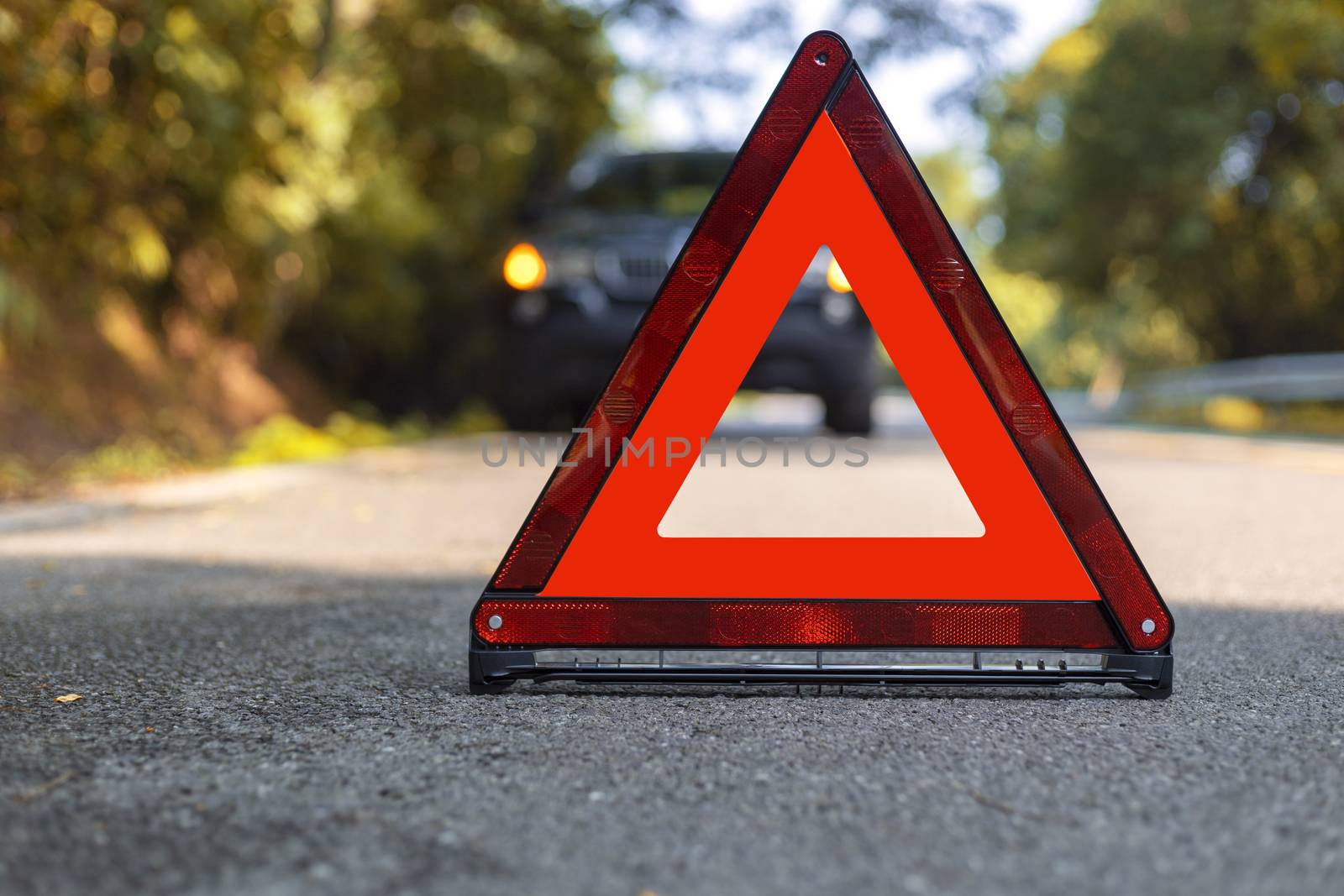 Red triangle, red emergency stop sign, red emergency symbol and black car stop and park on road.