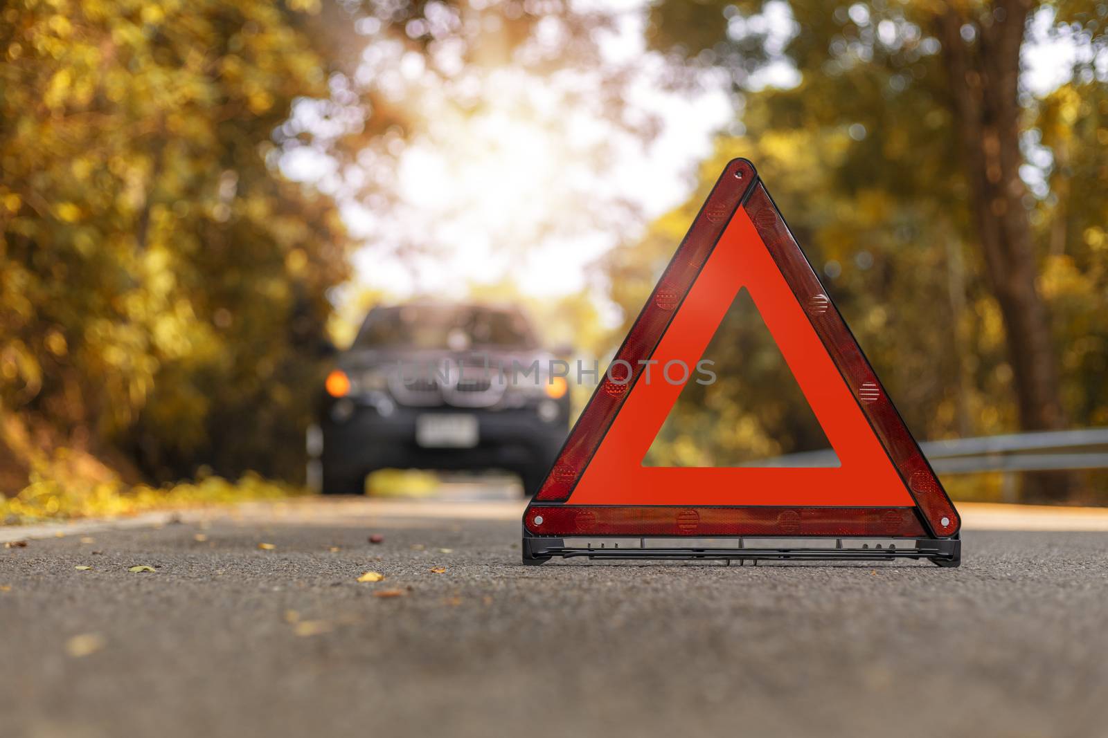 Red triangle, red emergency stop sign, red emergency symbol and black car stop and park on road.