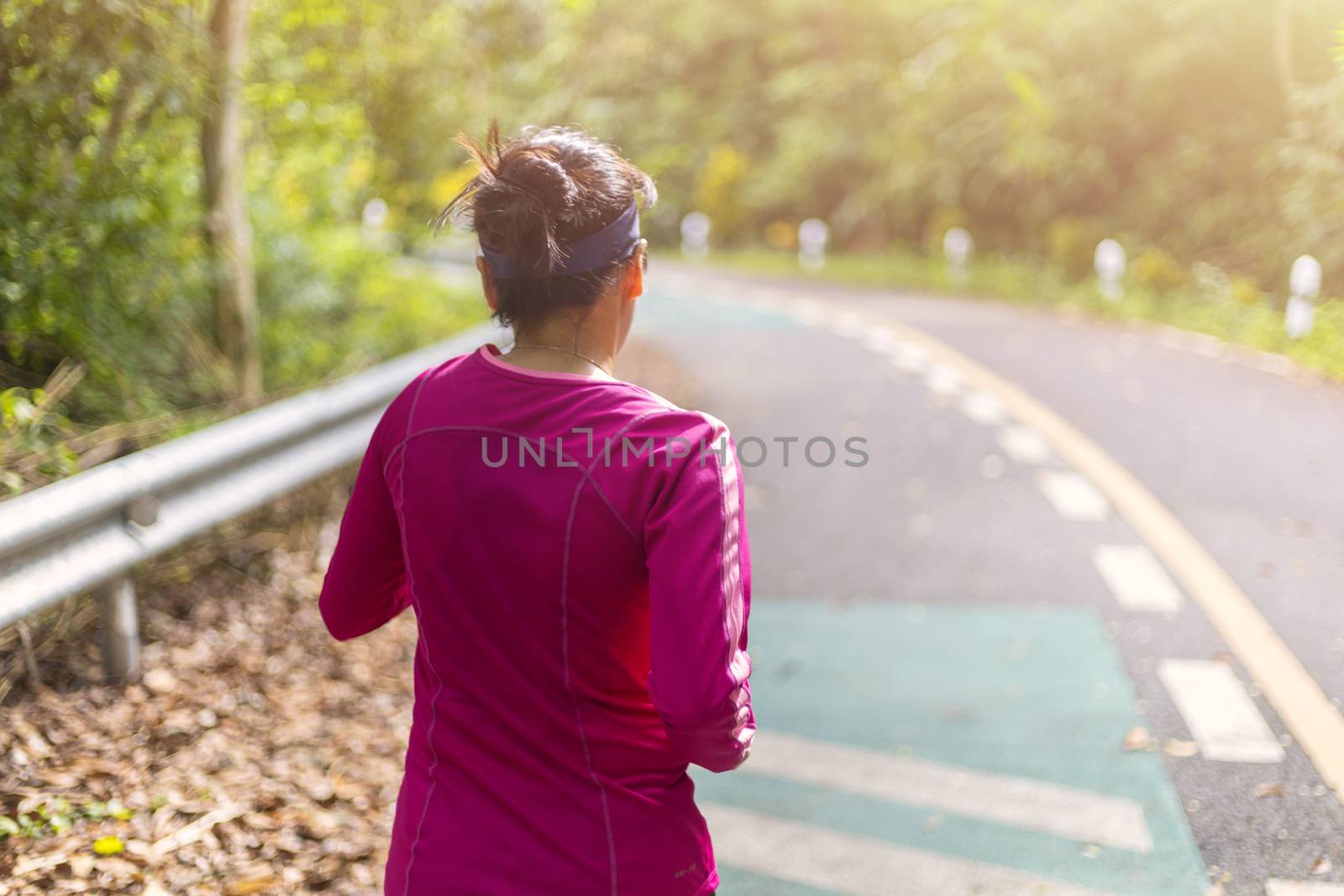 Women with pink long sleeve runing on road in morning time.