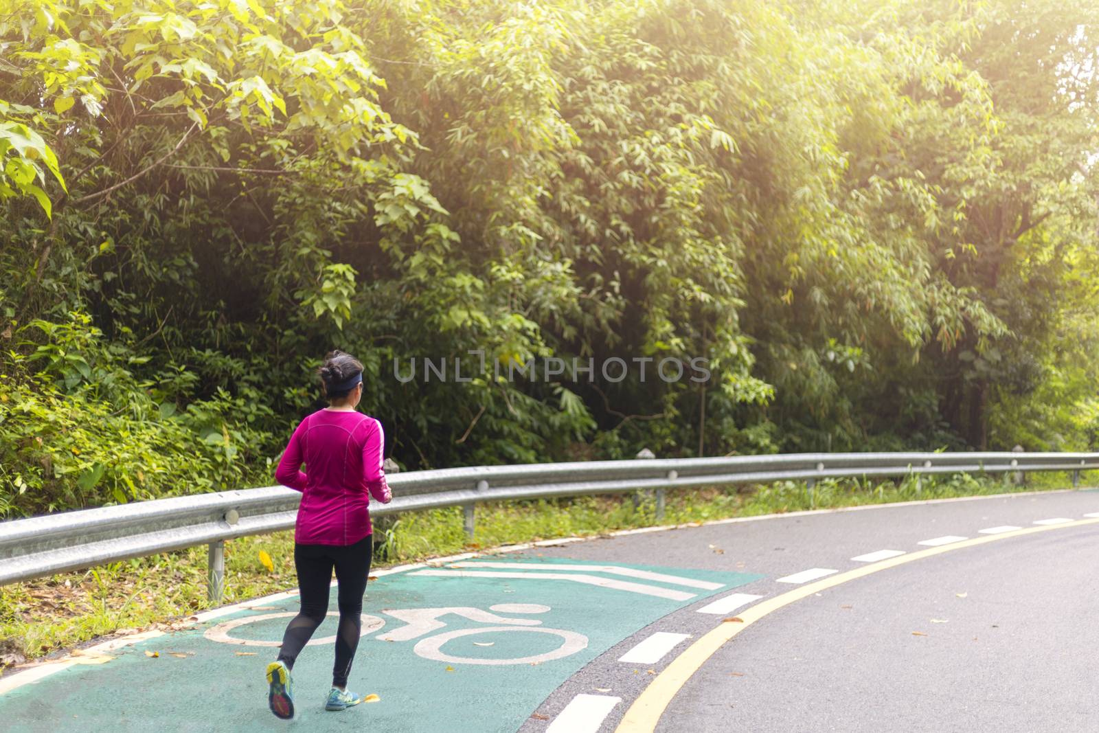 Women with pink long sleeve runing on road in morning time.
