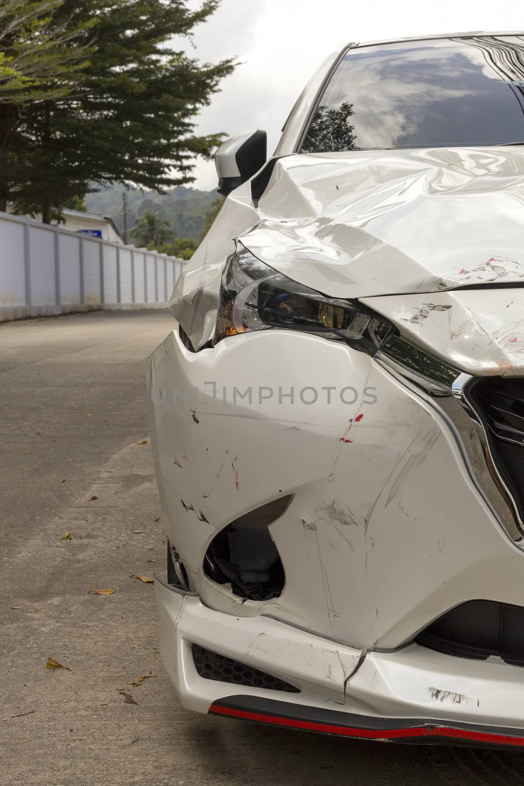 Front of white color car big damaged and broken by accident on road parking can not drive any more. With copy space for text or design