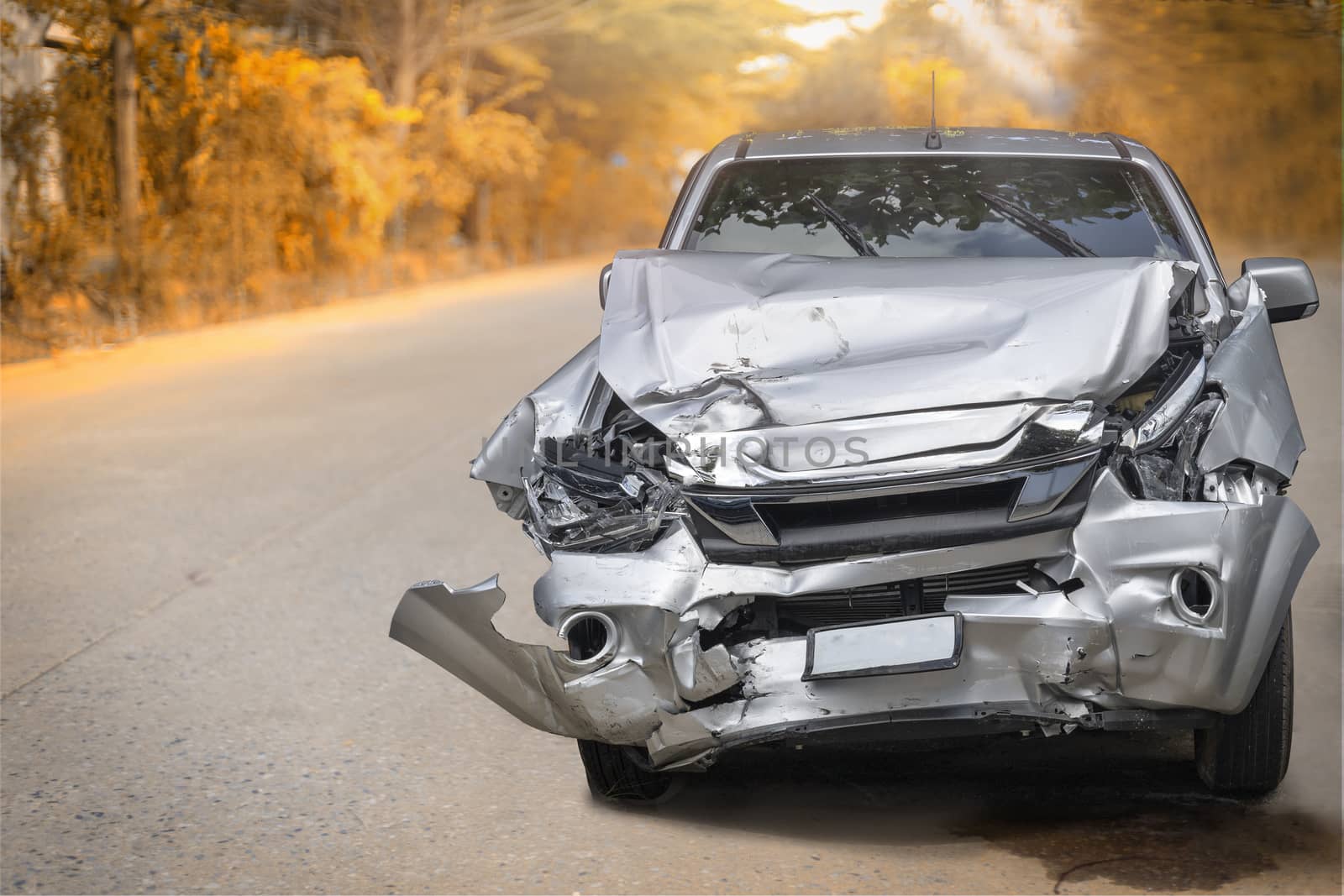 Artumn road. Front of gray color car big damaged and broken by accident on road parking can not drive any more. With copy space for text or design