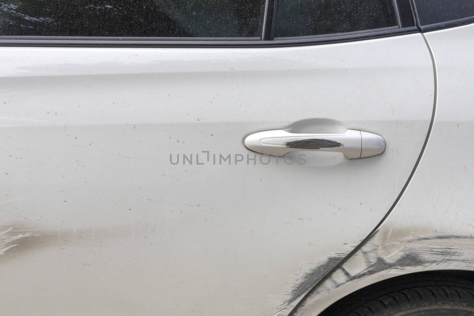 Car door handle and white car door have scratches from damaged by accident