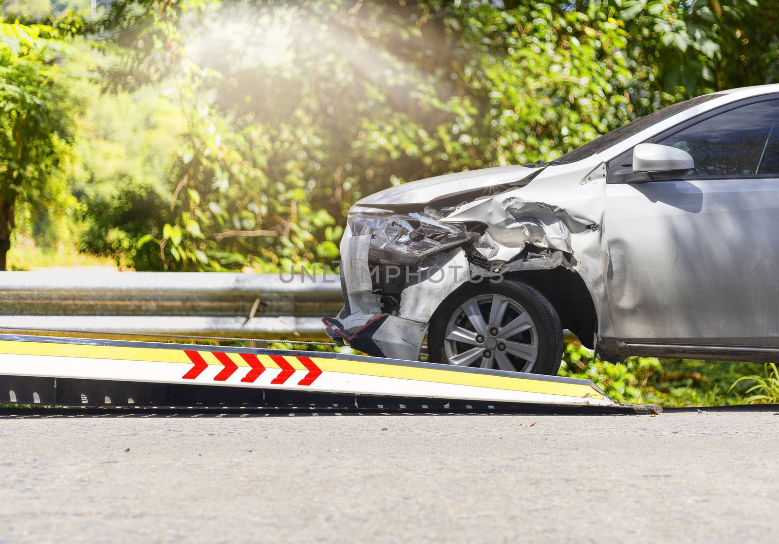 accident Car Slide on  truck for move. White car have damage by accident on road take with slide truck move . 