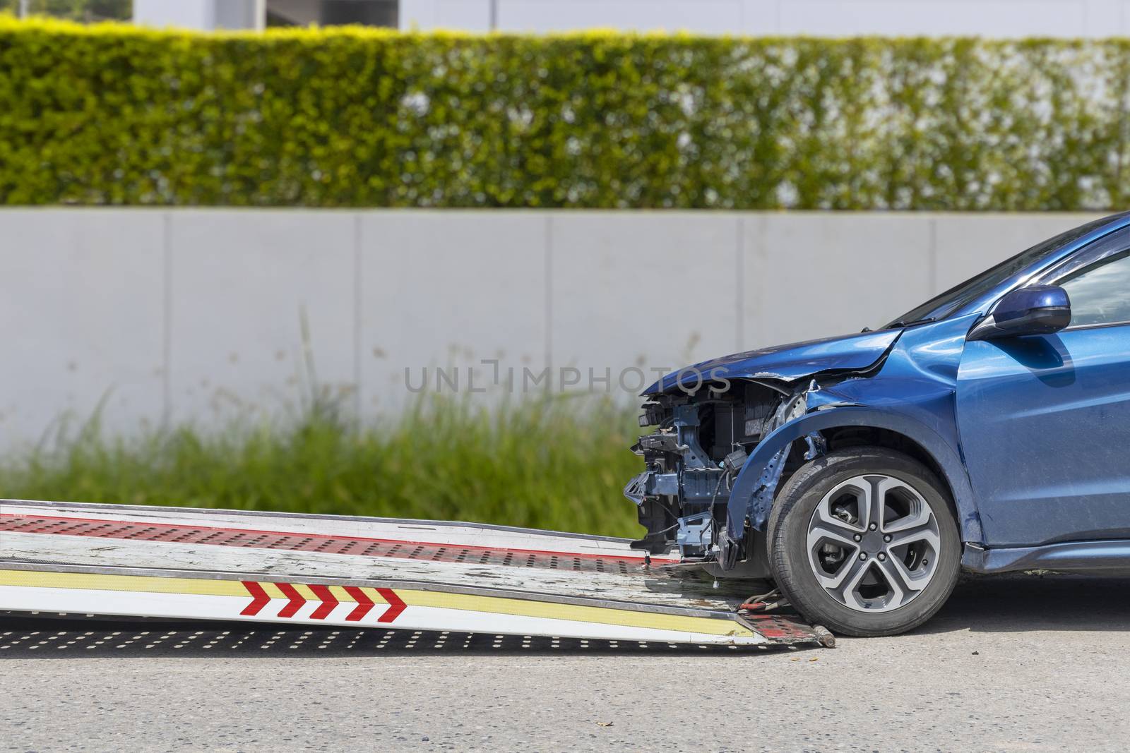 accident Car Slide on  truck for move. Blue car have damage by accident on road take with slide truck move .