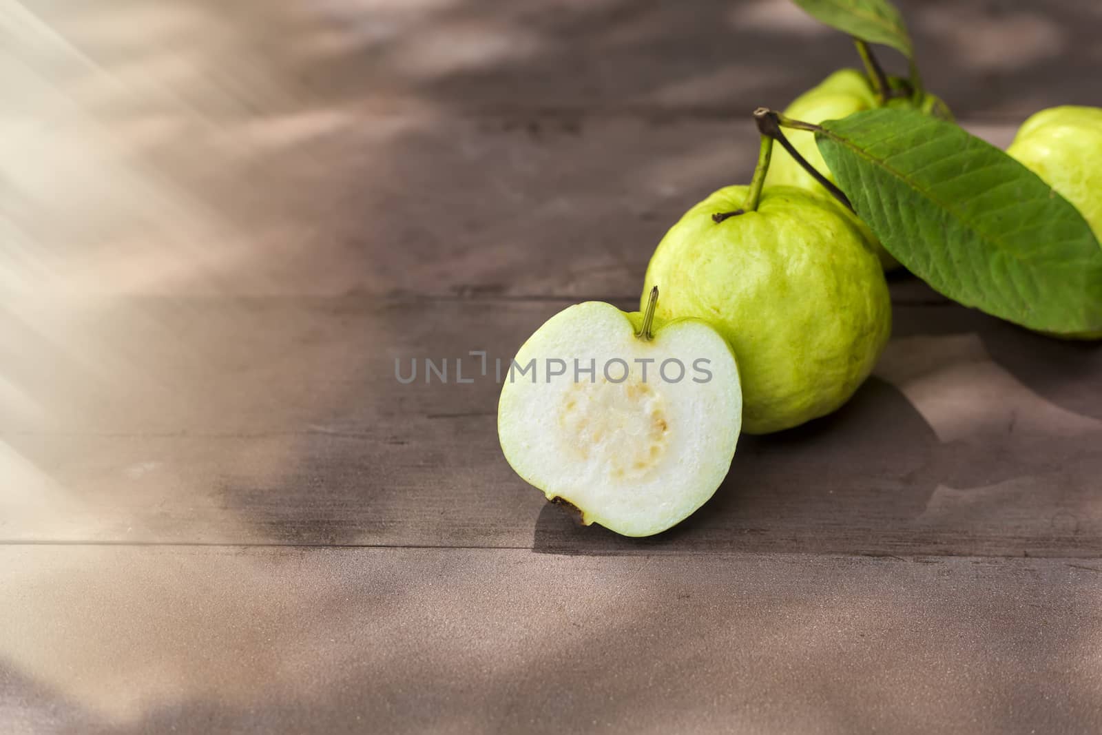 Fresh guava fruit on wood table with sun ray. Fresh guava slide.