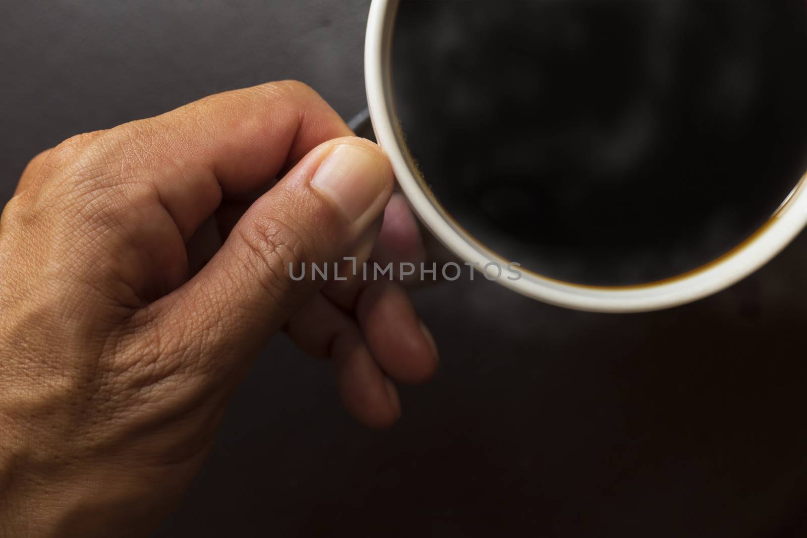 Top view close up hand man hold coffee cup . Black coffee in coffee cup.