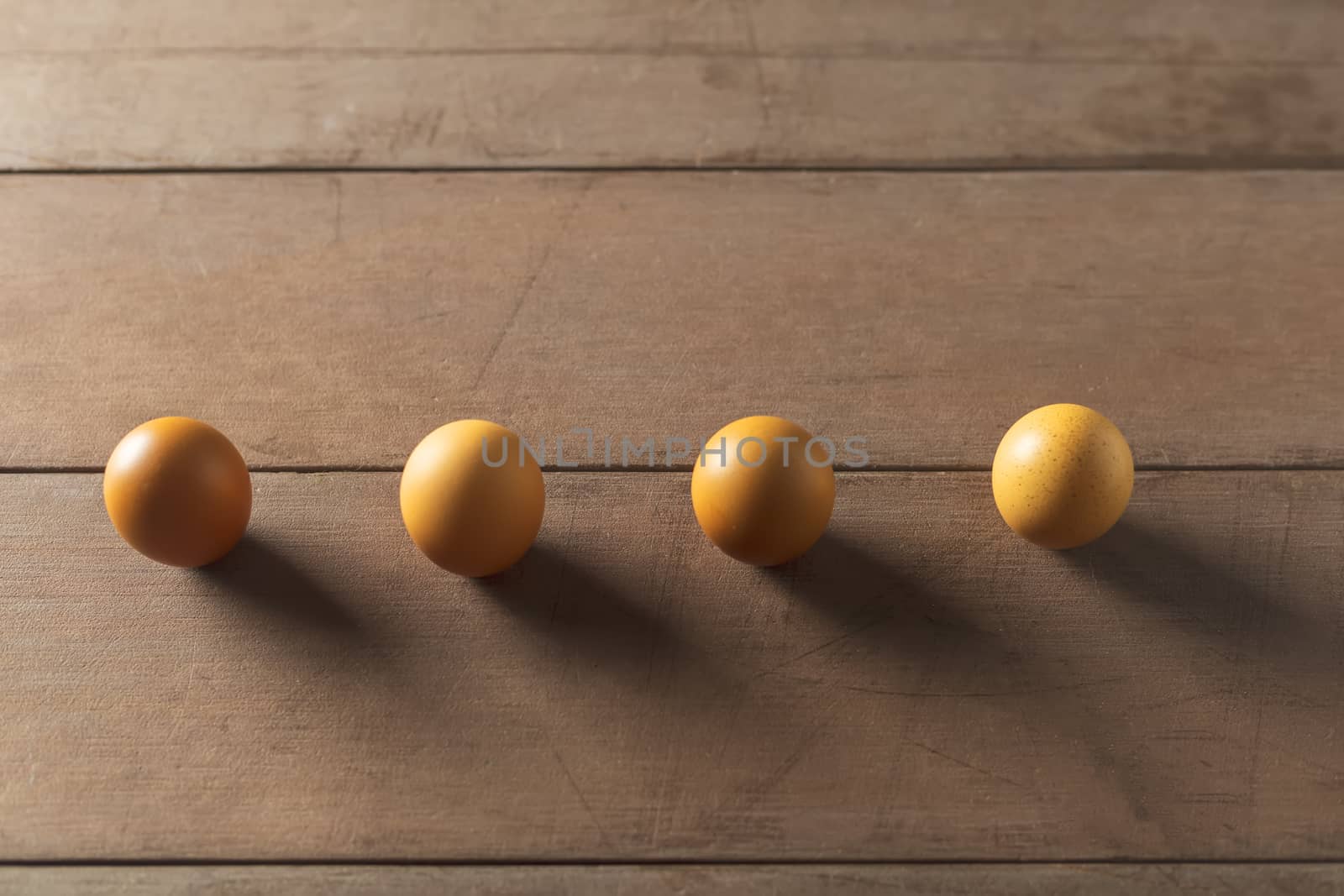 Top view 4 eggs on wood table with copy space. social distancing concept.
