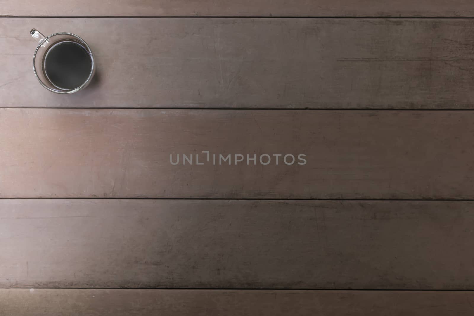 Top view black coffee cup on old wood table. coffee in handle cup with copy space. Hot black coffee with smoke.