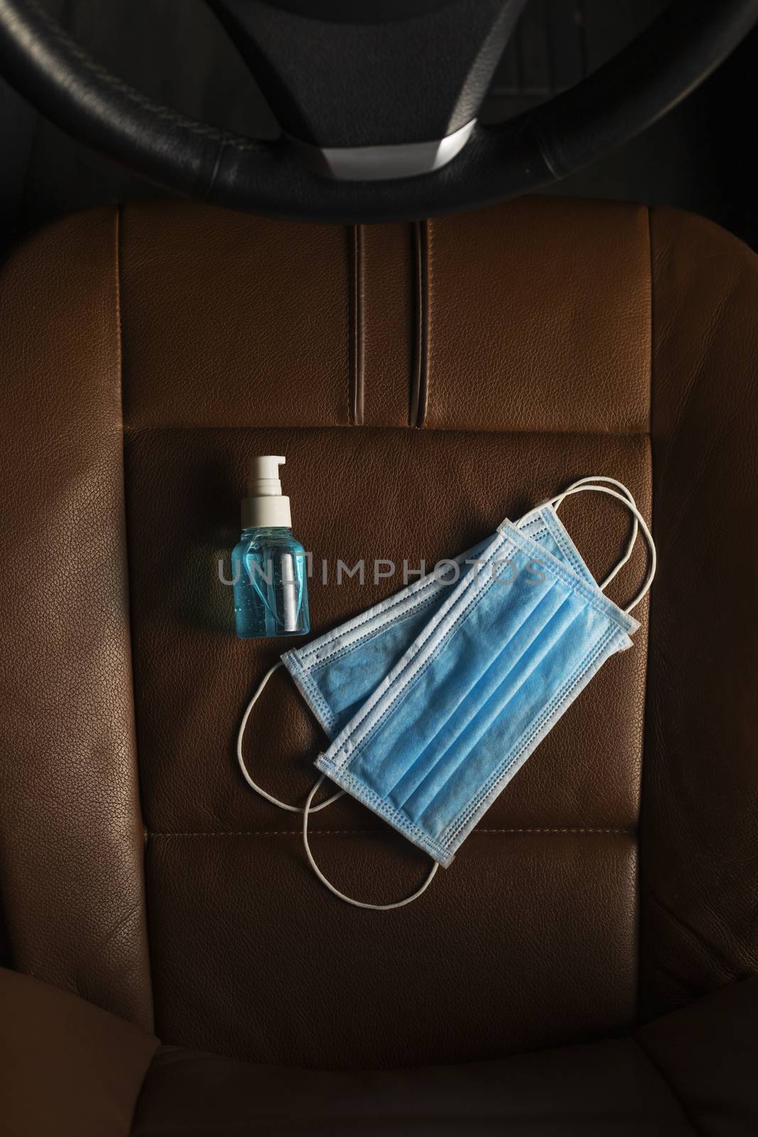 Top view Medical mask Alcohol Hand sanitizer gel on The car seat .