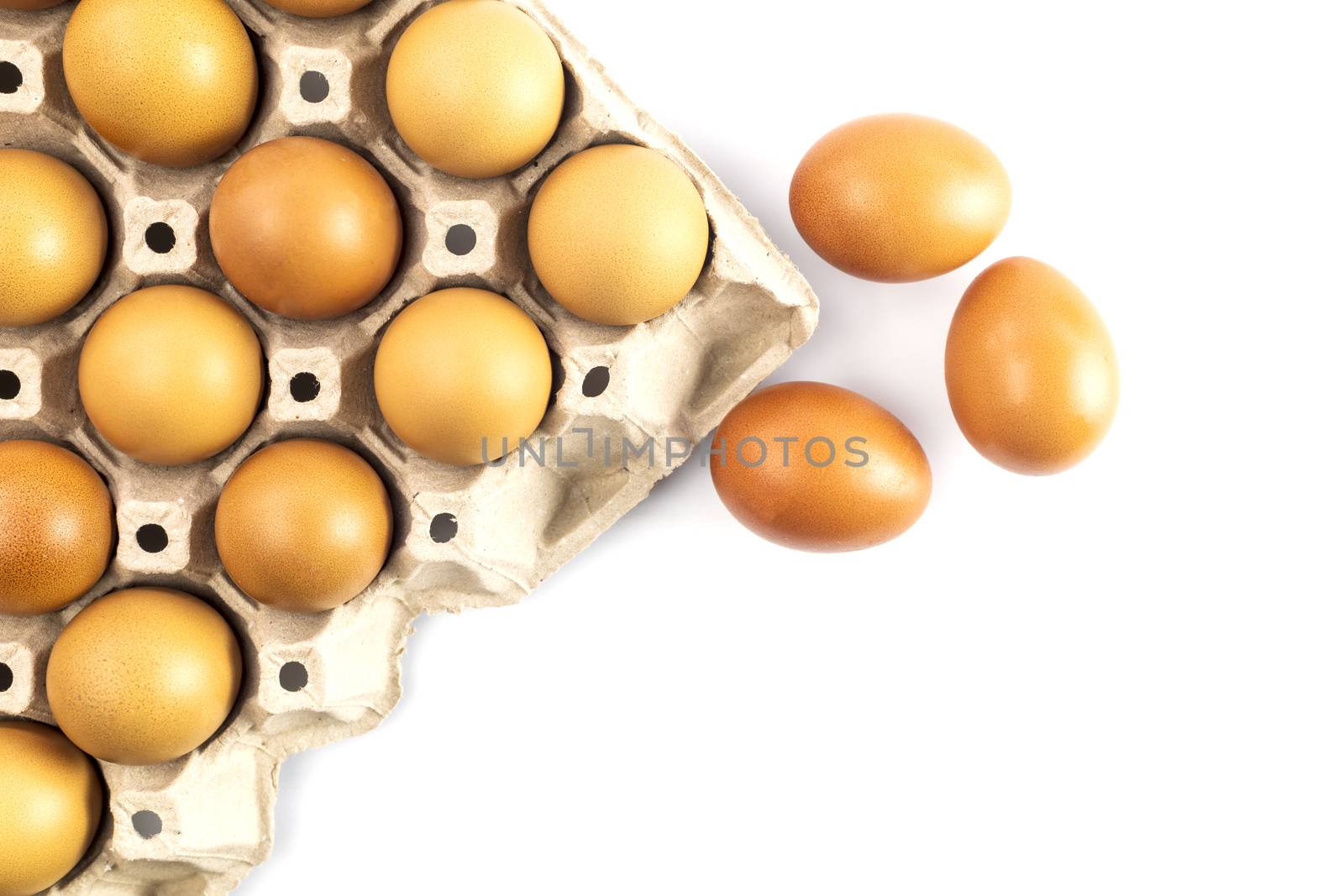 Top view chicken fresh eggs in cardboard egg box holder and 3 fresh eggs outside isolated on white background.