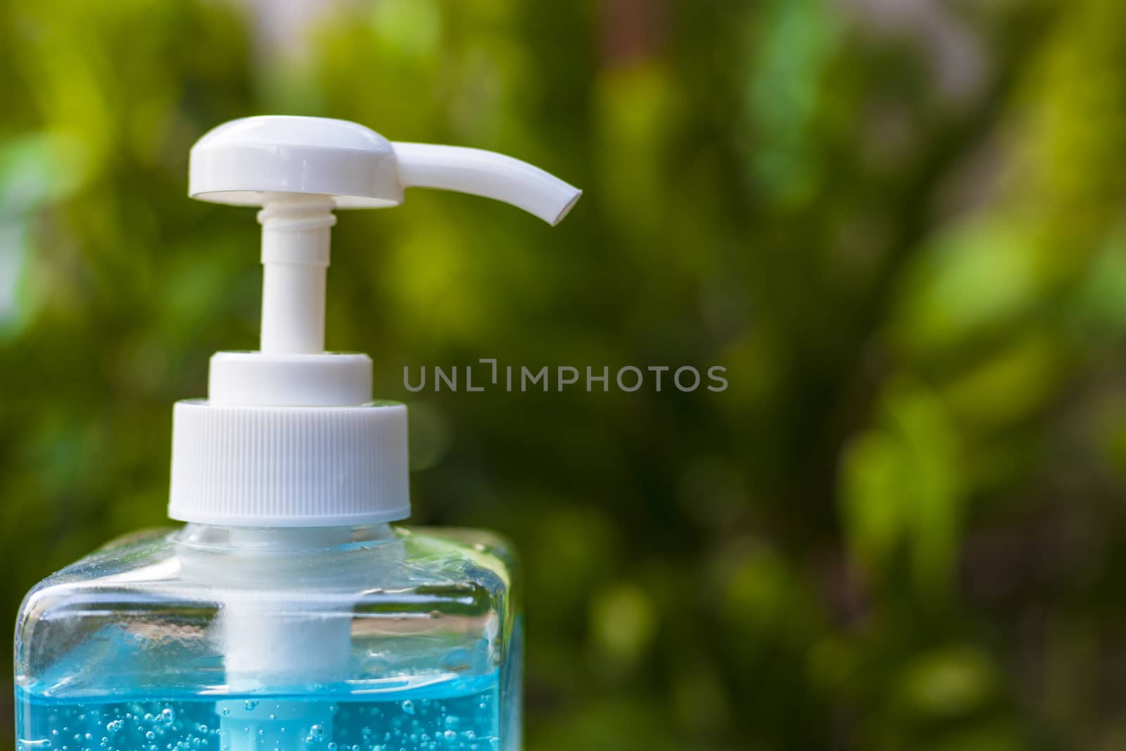 Close up pump of Blue alcohols gel bottle on nature background.