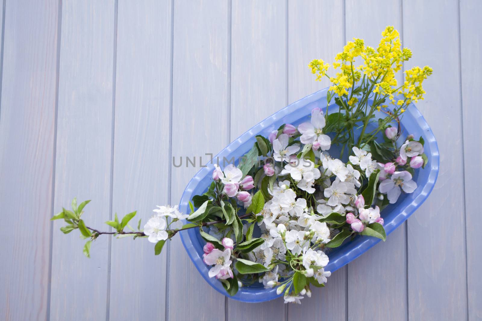 Festive flower composition frame on the blue planks wooden background. Overhead view.