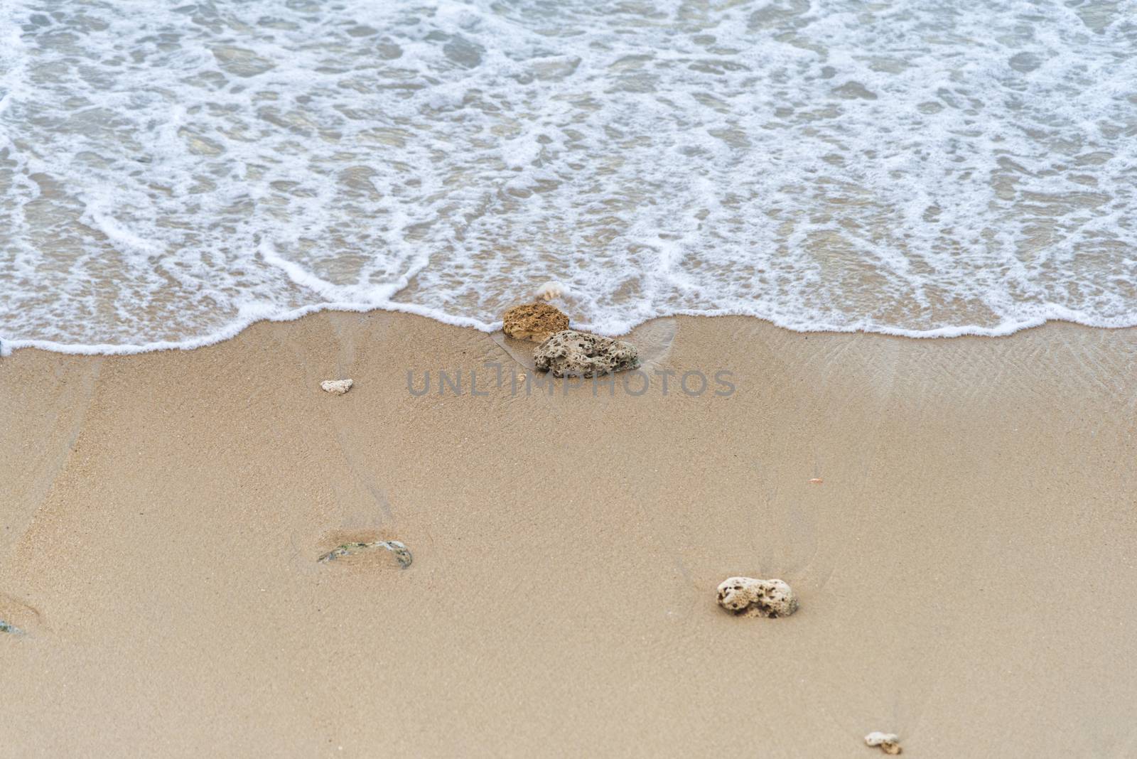 Top view Soft wave from sea come to wet sand beach background. With copy space for text or design