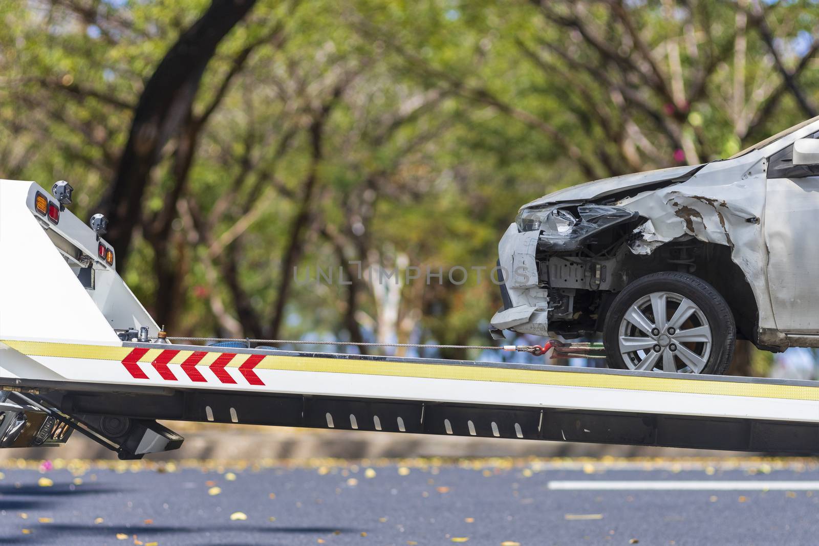 accident Car Slide on  truck for move. Gray car have damage by accident on road take with slide truck move . 
