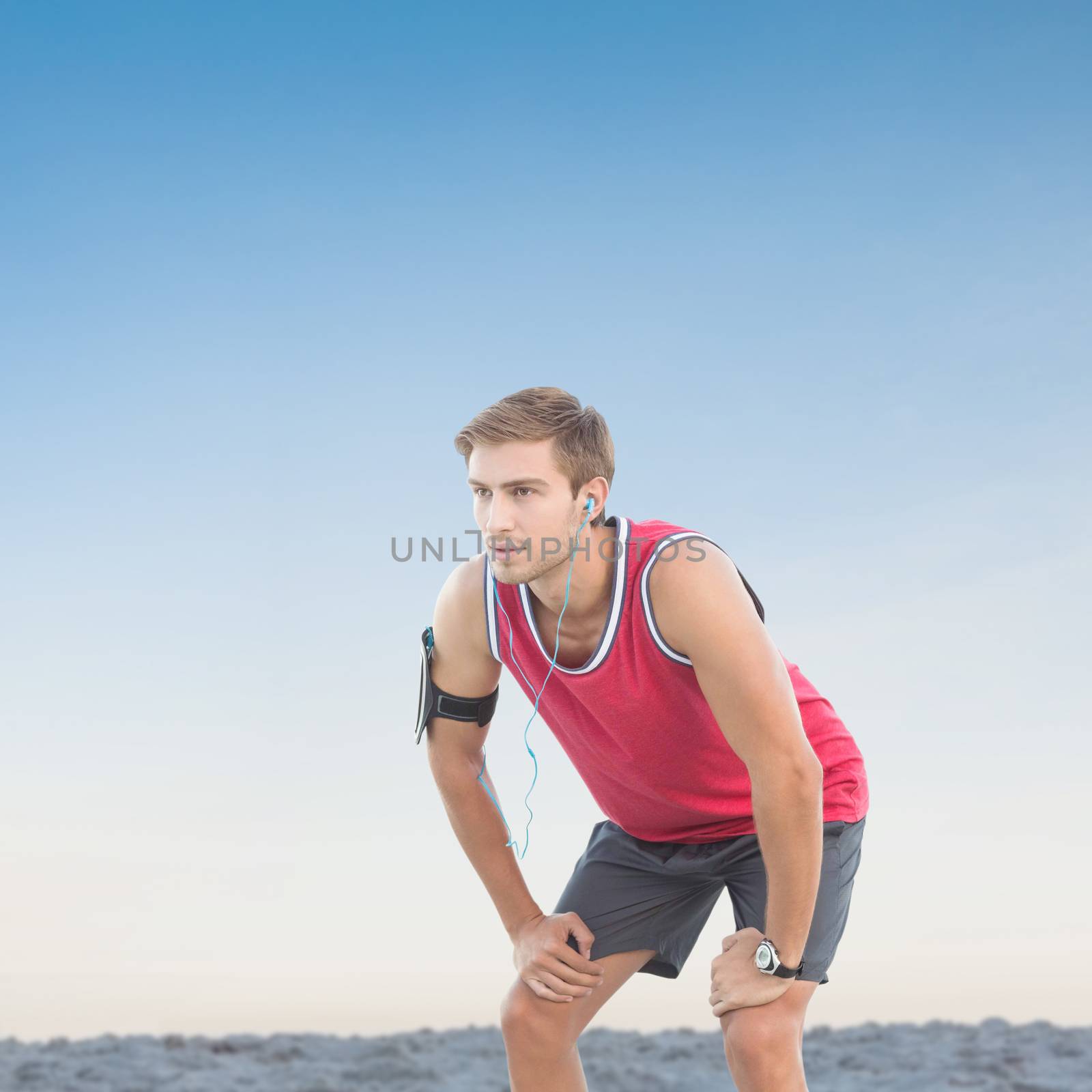 Fit man taking break against horizon over the sand