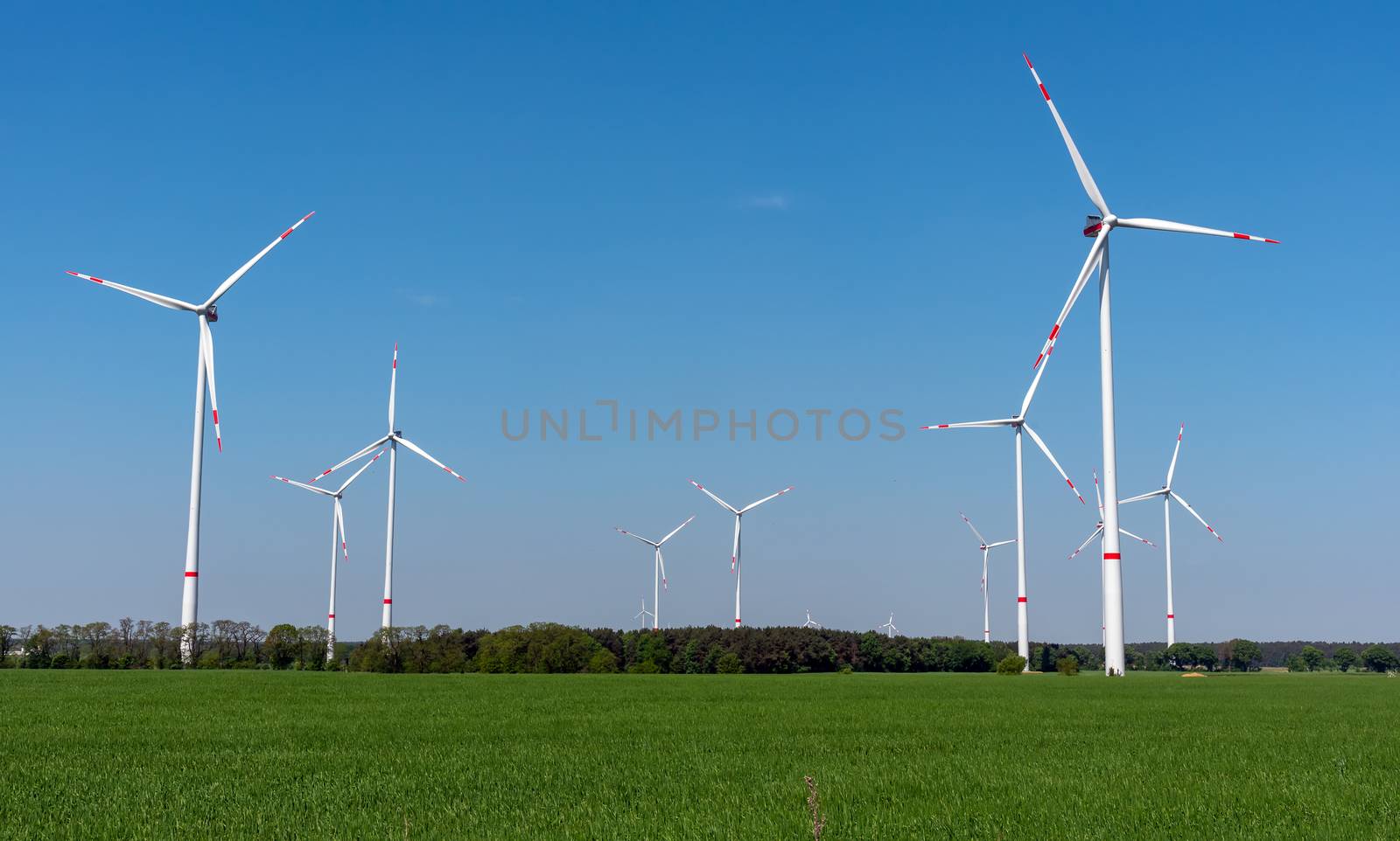 Wind power plants, green fields and blue skies seen in rural Germany