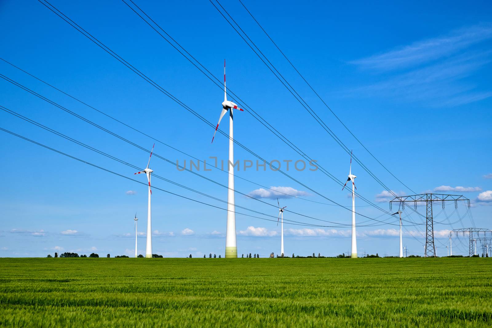 Power lines and wind engines on a sunny day seen in Germany