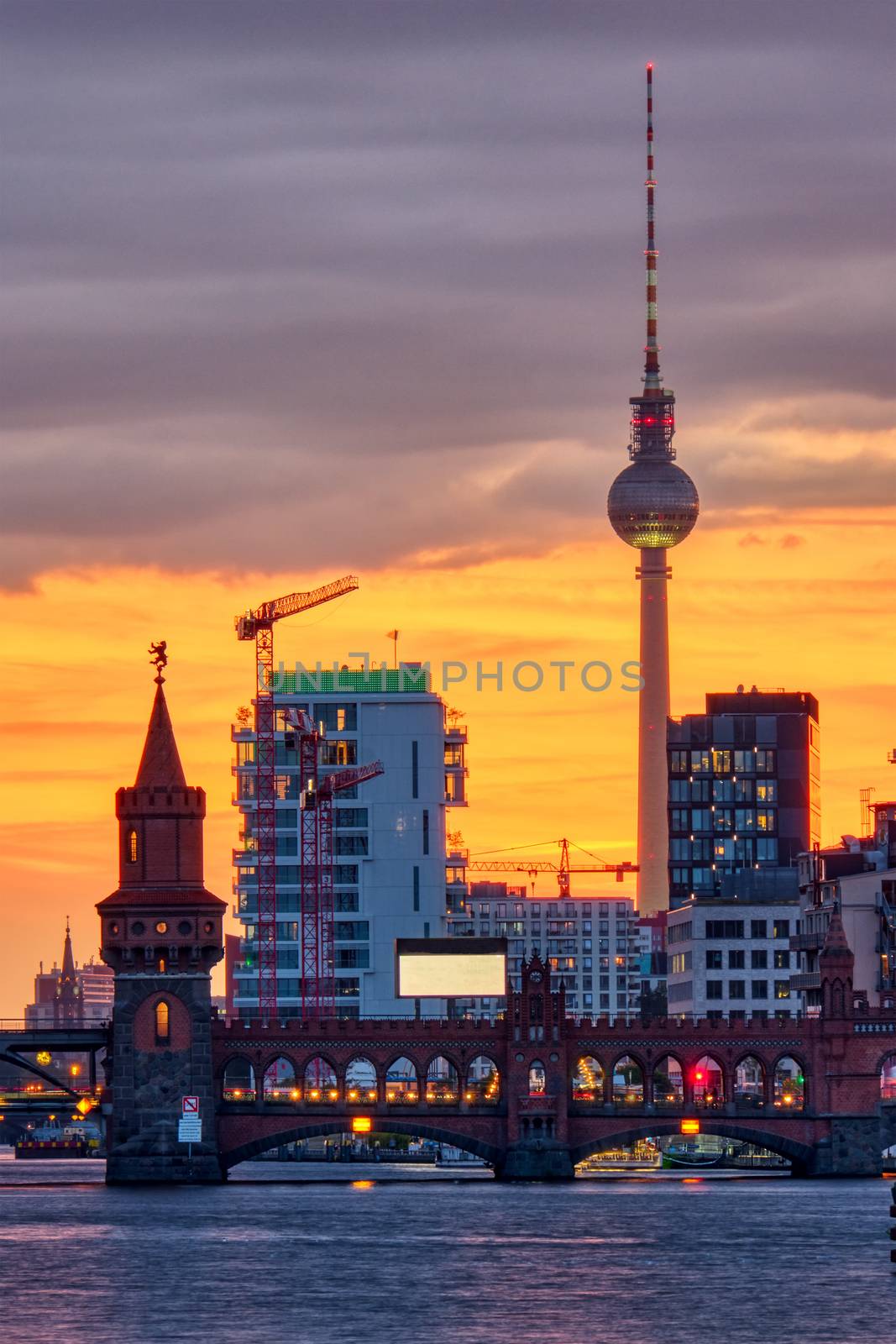 Dramatic sunset at the Oberbaum Bridge and the famous Television Tower in Berlin