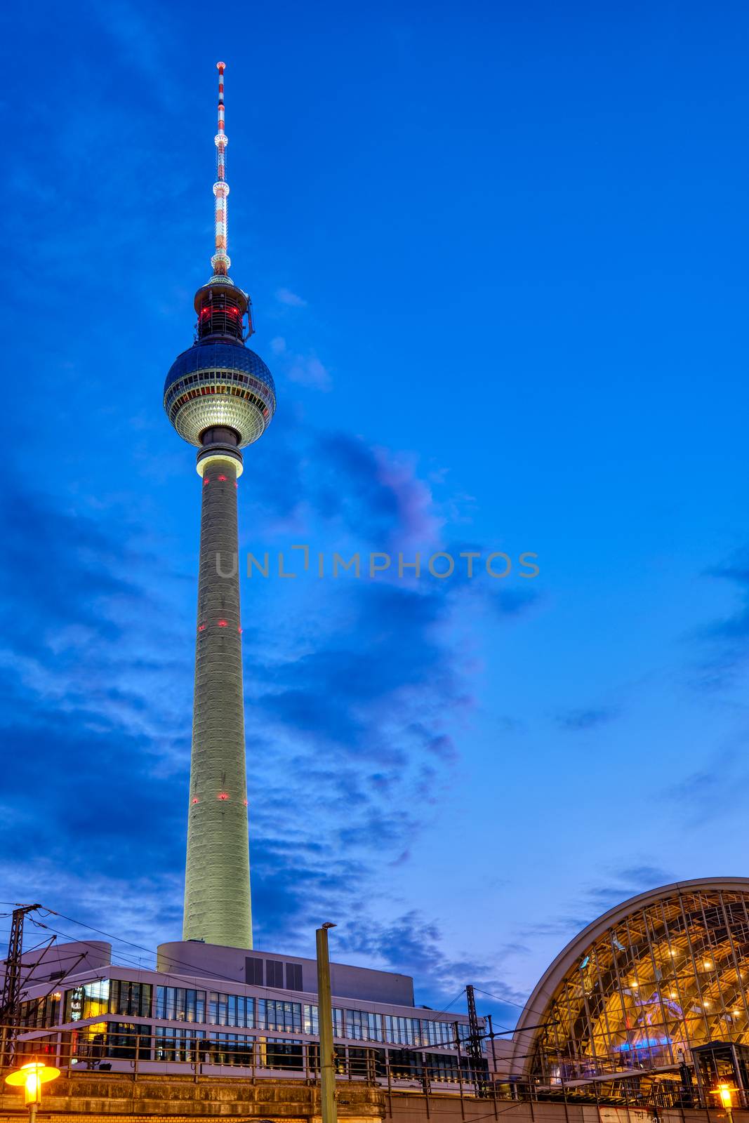 The famous Berlin Television Tower and the trainstation at Alexanderplatz at night