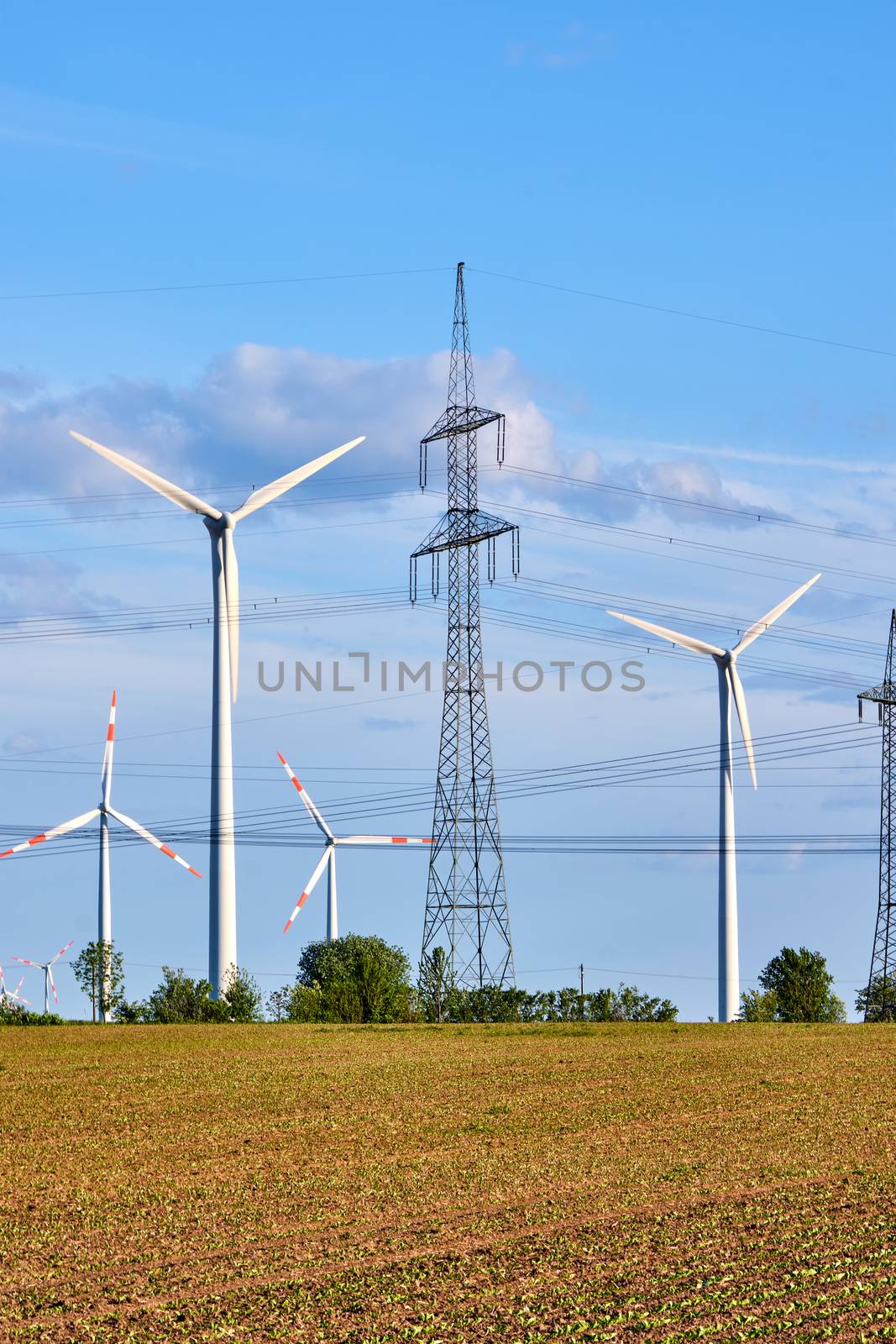 An electricity pylon and wind energy generators seen in Germany