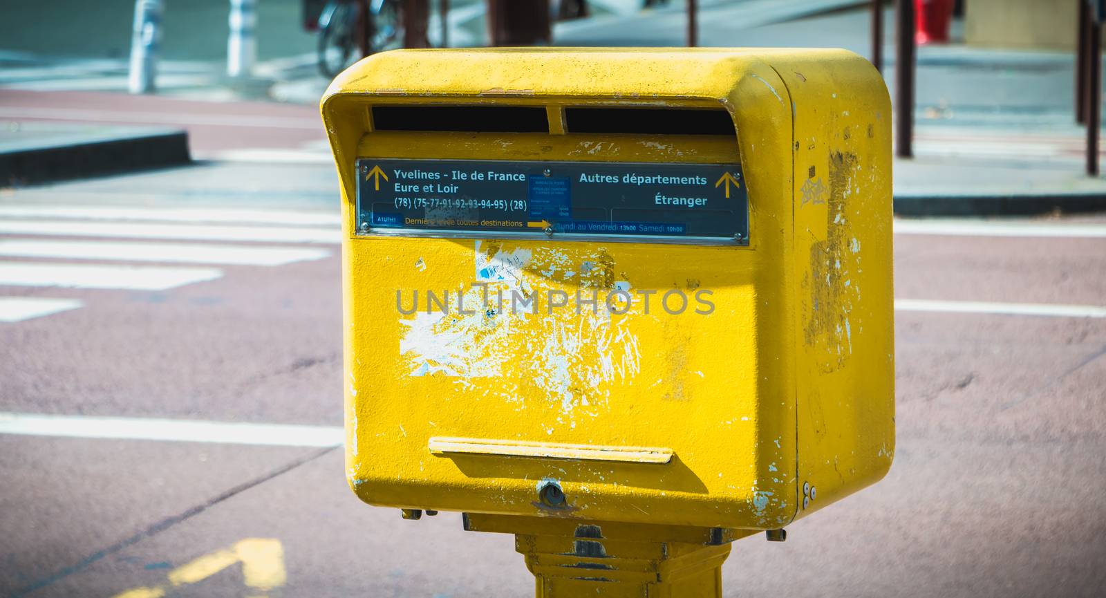 Versailles, France - October 9, 2017: Yellow Post mailbox in the city center on a fall day