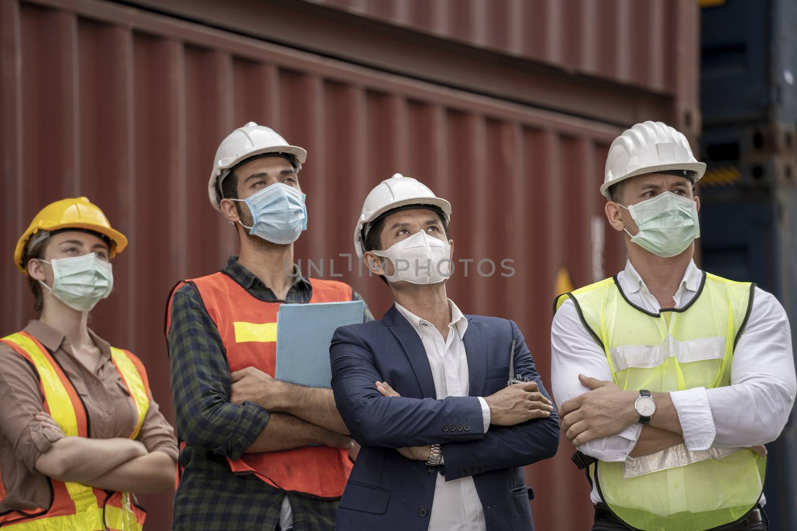 Business man and  Factory workers wearing in a medical mask and safety cloth at outdoor factory cargo warehouse.