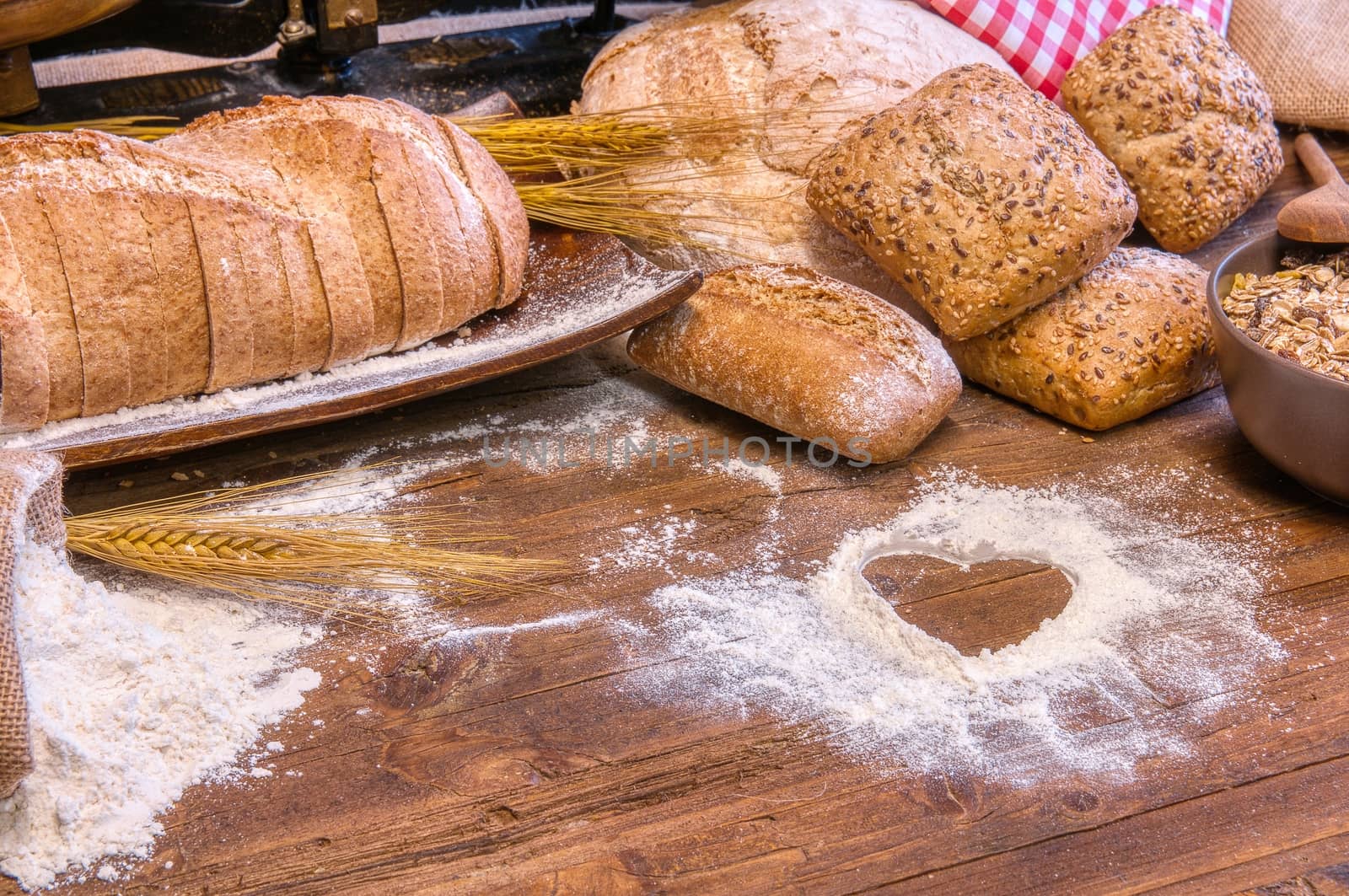 Bread and flour on a rustic wooden table. by CreativePhotoSpain