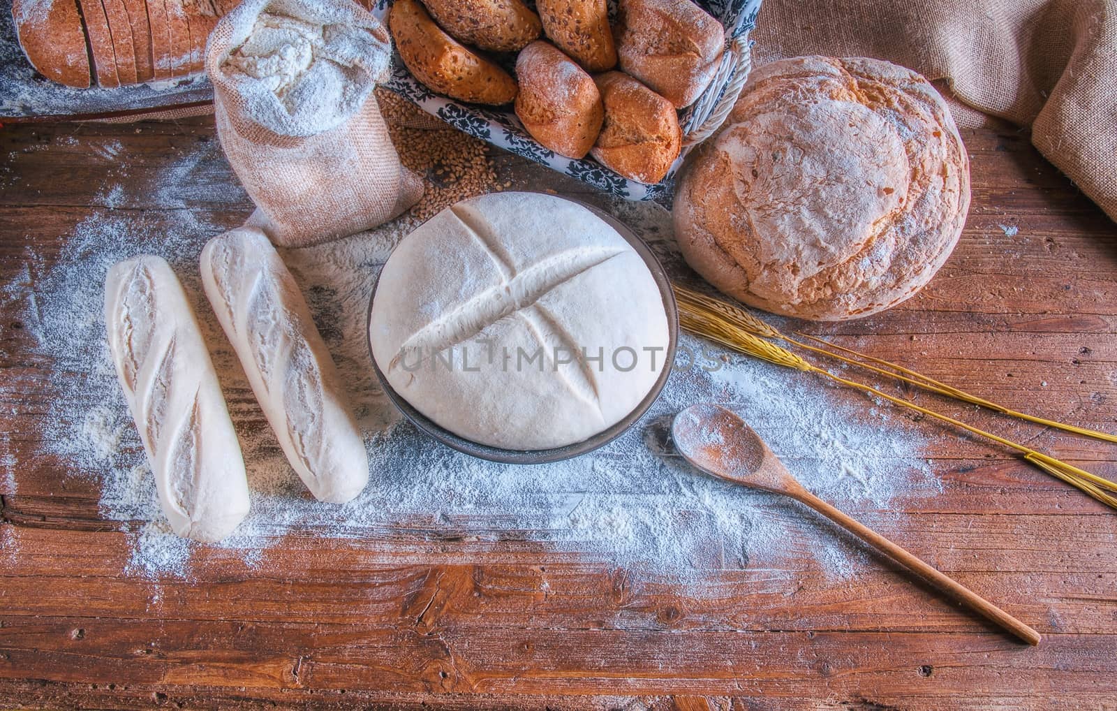 Bread and flour on a rustic wooden table. by CreativePhotoSpain