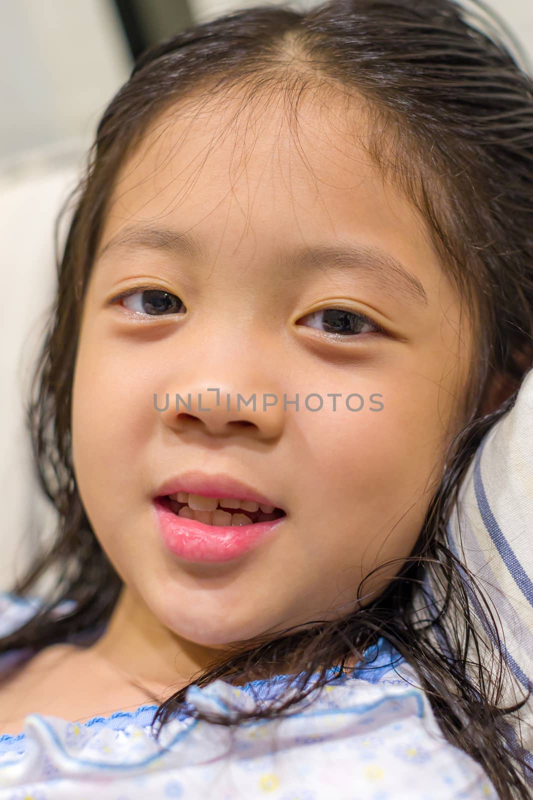 Child, girl, in pajamas in bed, portrait head shot.