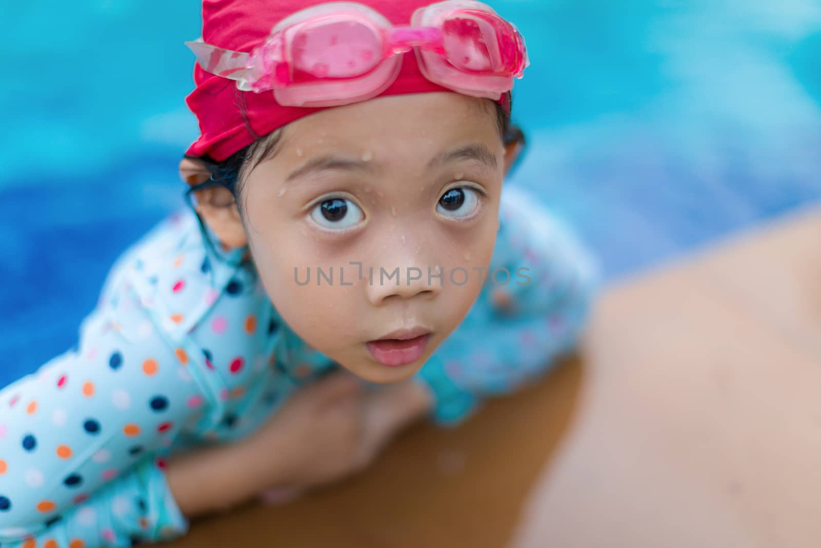Asian girl at the edge of swimming pool.