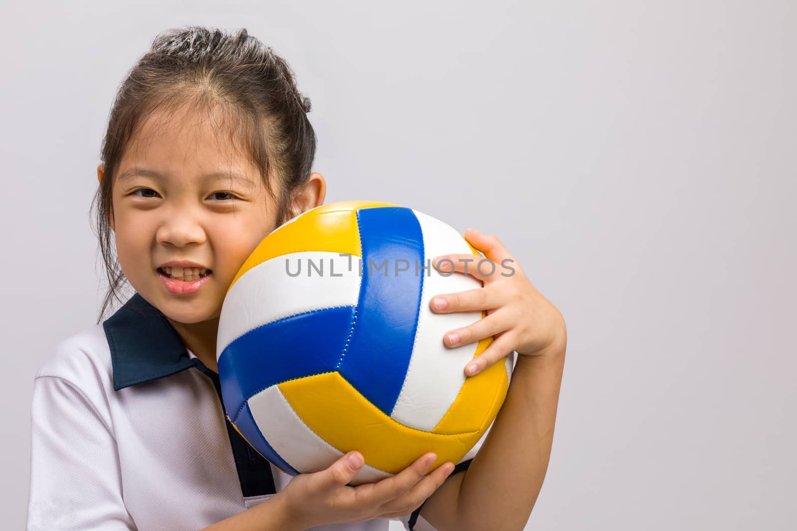 Child holding ball, studio shot, isolated on white.