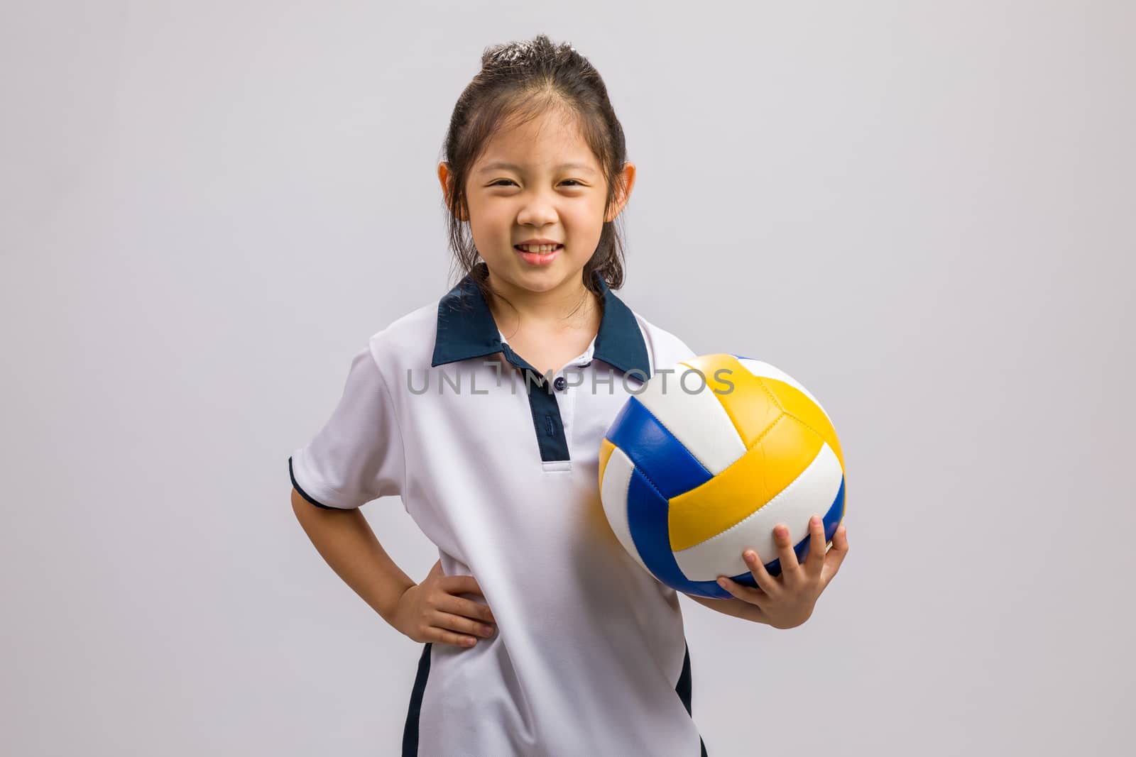Child holding ball, studio shot, isolated on white.