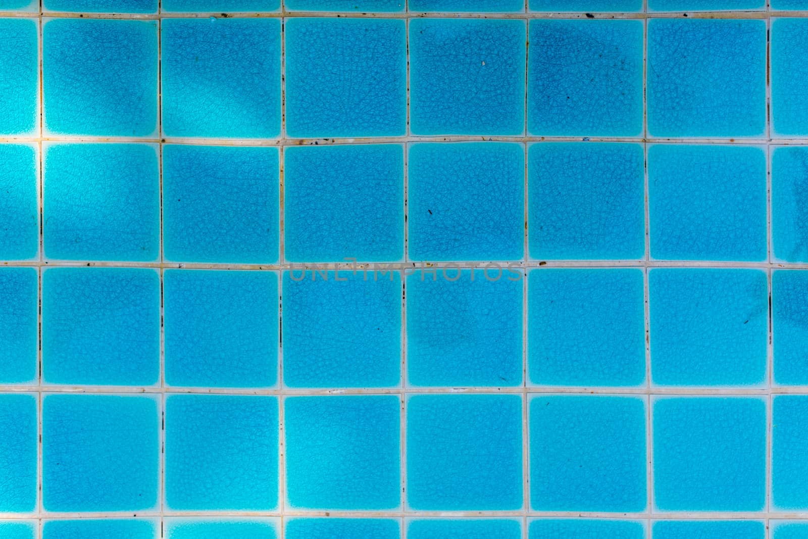 Blue tile of swimming pool in square pattern.