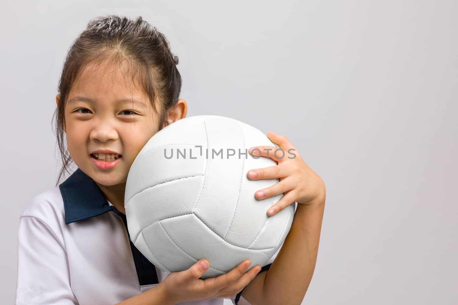 Child holding ball, studio shot, isolated on white.