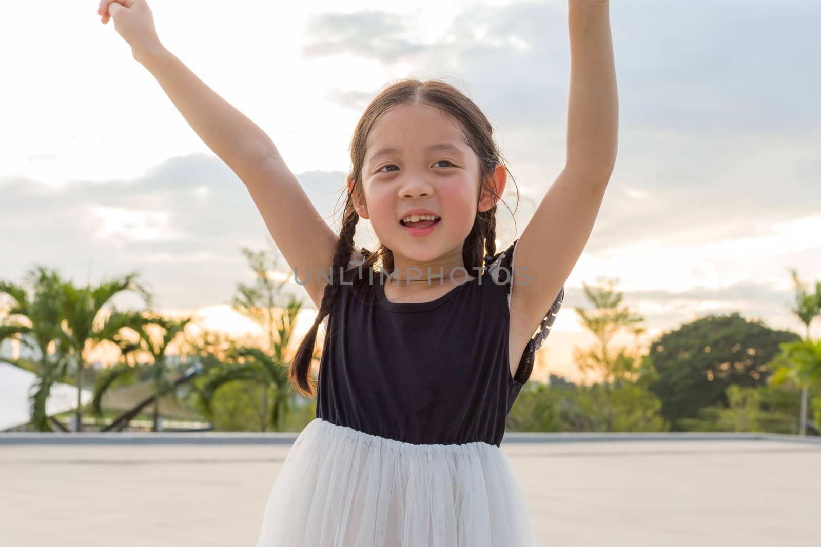 Child raising hands for success with happiness and joy.