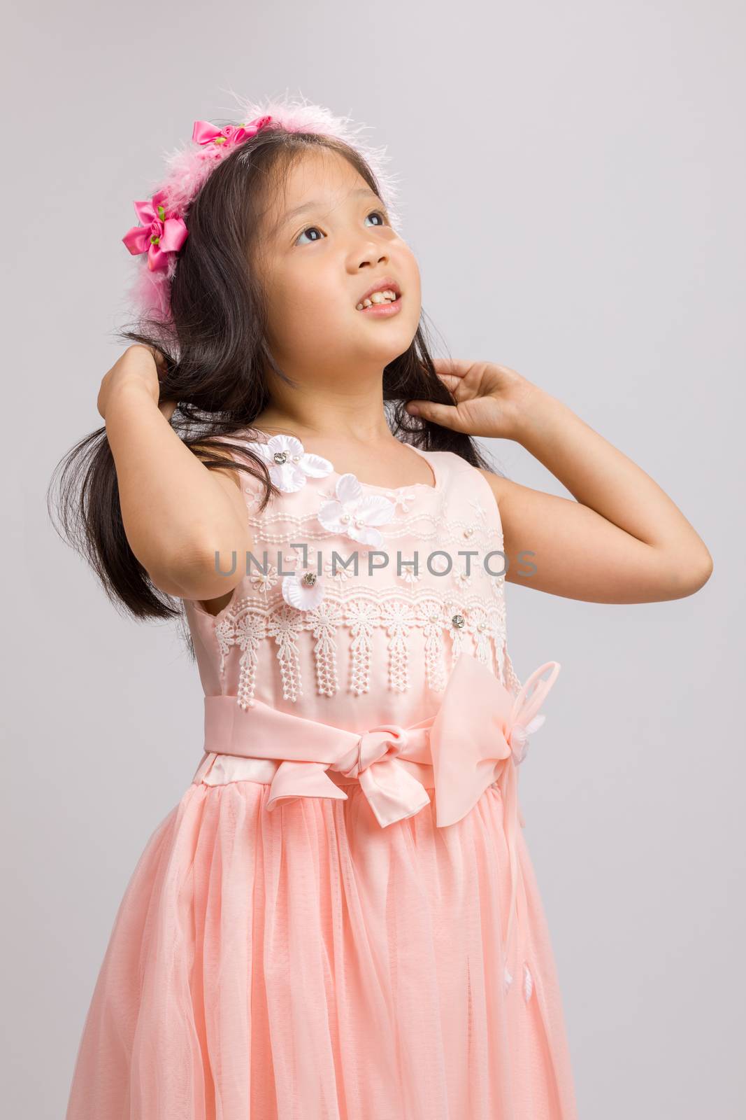 Child in pink dress, isolated on white background.