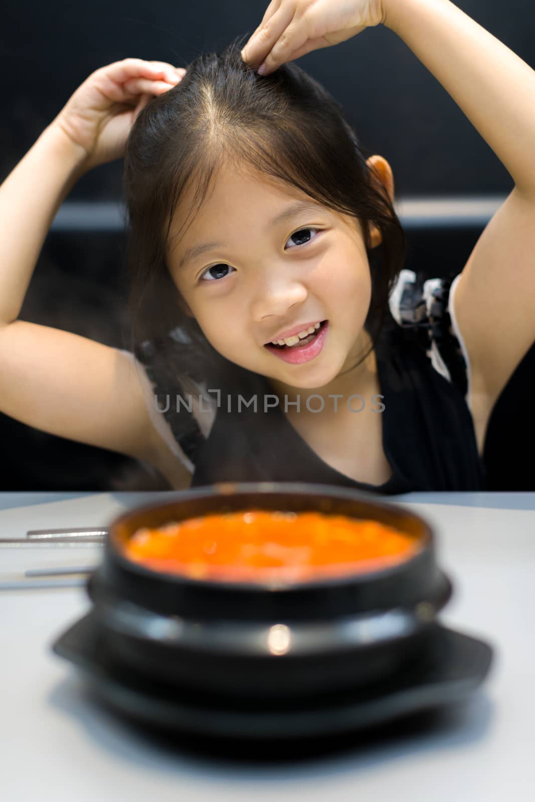 Asian kid with traditional Korean Kimchi soup.