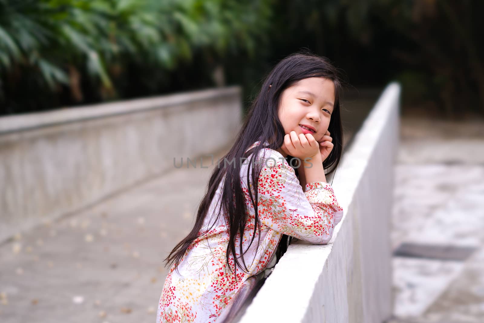 Asian child smiling with happiness in outdoor park.