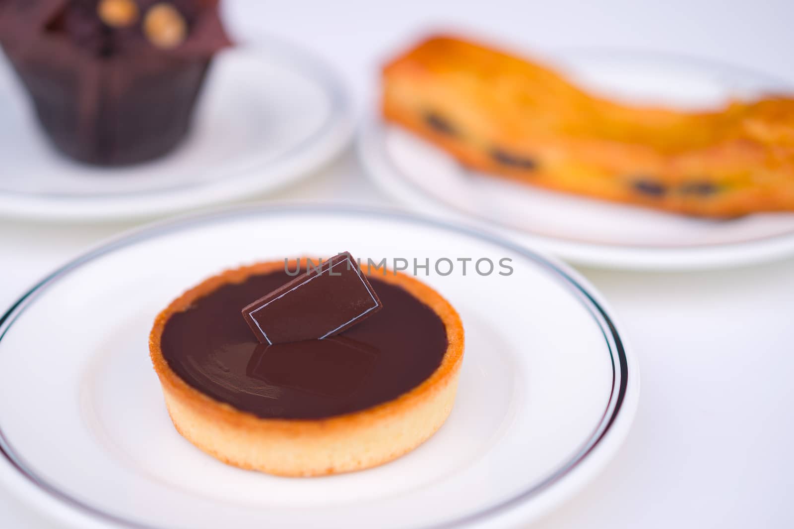 Pastry snack, chocolate bakery dessert in white plate.