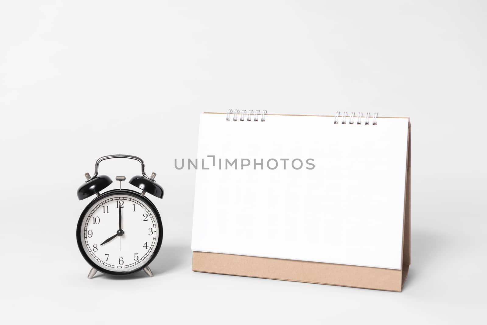 Blank paper spiral calendar for mockup template advertising and branding with clock on gray background.