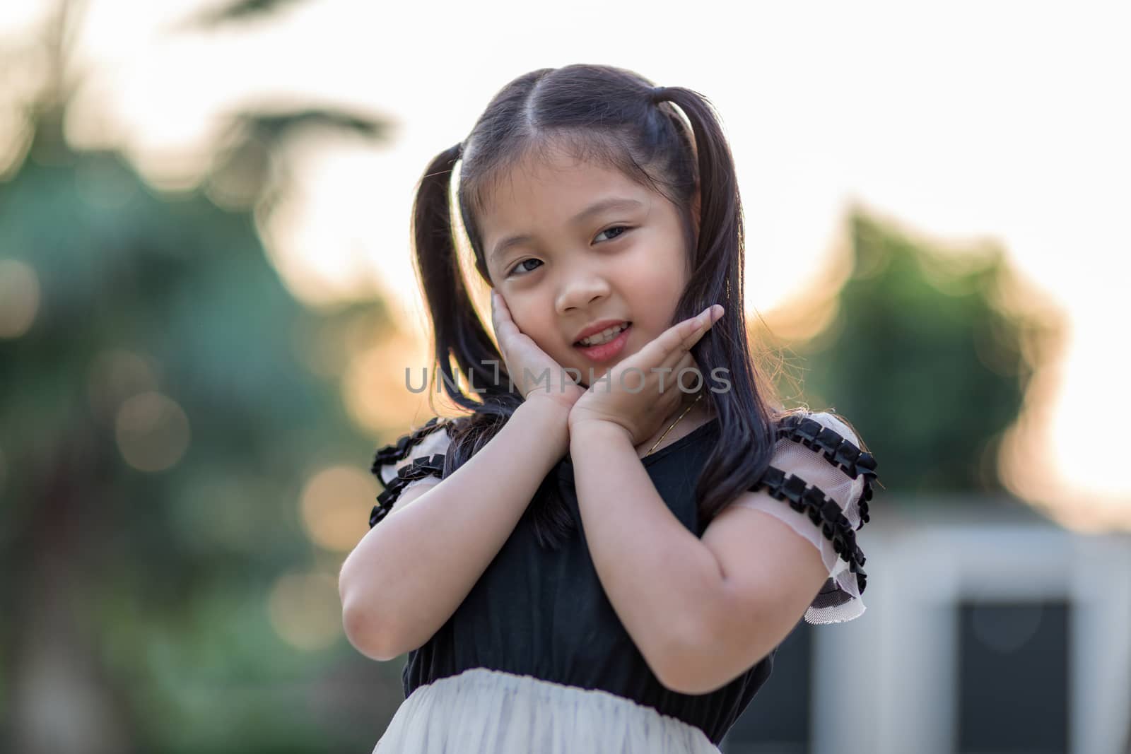 Asian kid smiling at outdoor swimming pool.