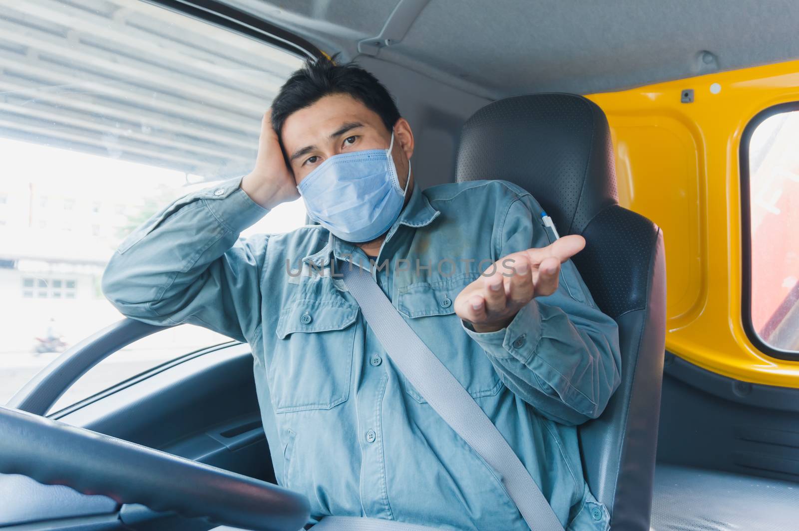 Close-up photos of Asian truck drivers wearing masks to protect against dust and the spread of the flu. Covid 19. Inside the car front